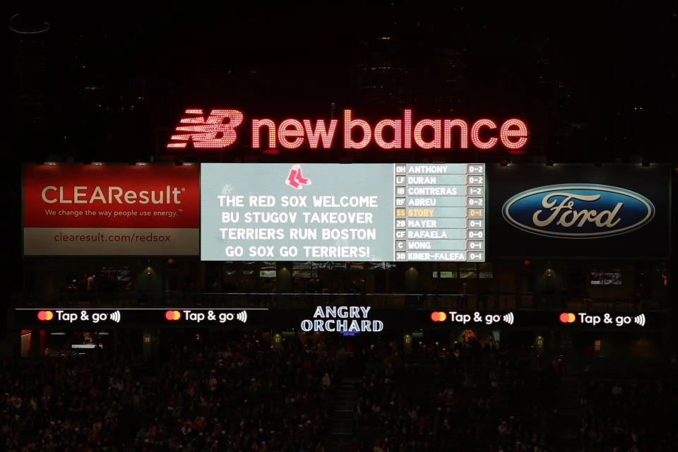 Digital scoreboard at a baseball stadium displaying a message welcoming the Boston Red Sox and mentioning the BU Stugov takeover.