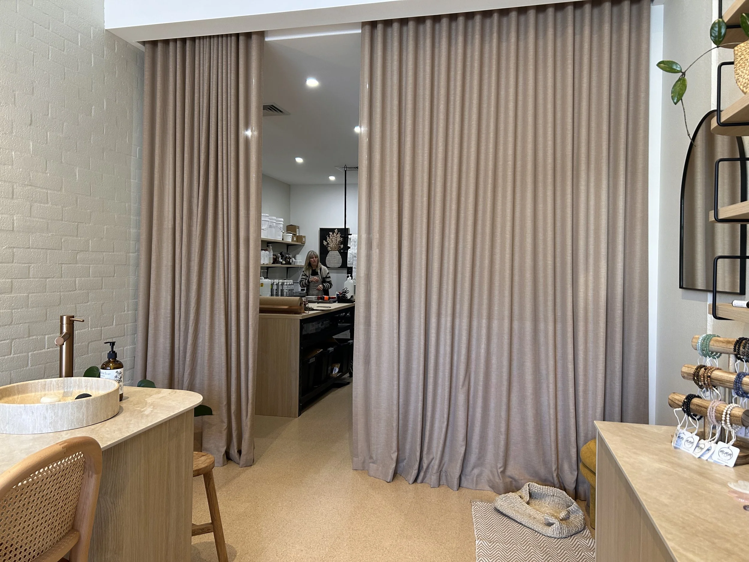 Parted full-height curtains framing the passage from Rasasara’s retail space into the rear workspace by Evans Curtains and blinds
