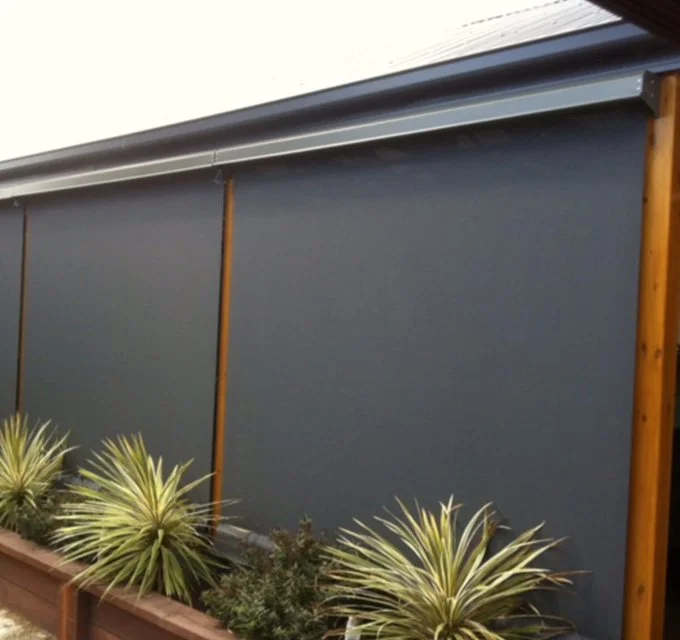 Blue privacy outdoor screen with plants in a garden bed in front.