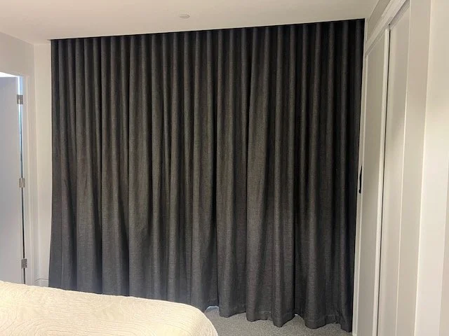 Dark floor-length bedroom curtains by Evans Curtains and Blinds, providing light control and a stylish finish.
