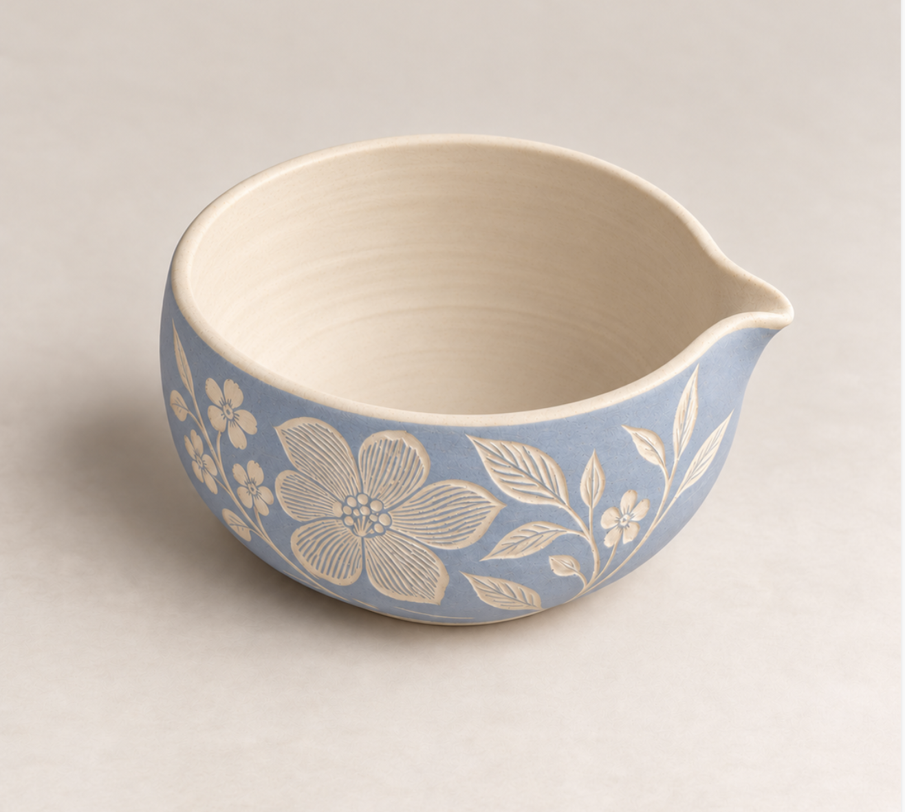 Hellblauer Matcha-Chawan mit Ausguss und floralem Sgraffito-Muster auf der Außenseite.