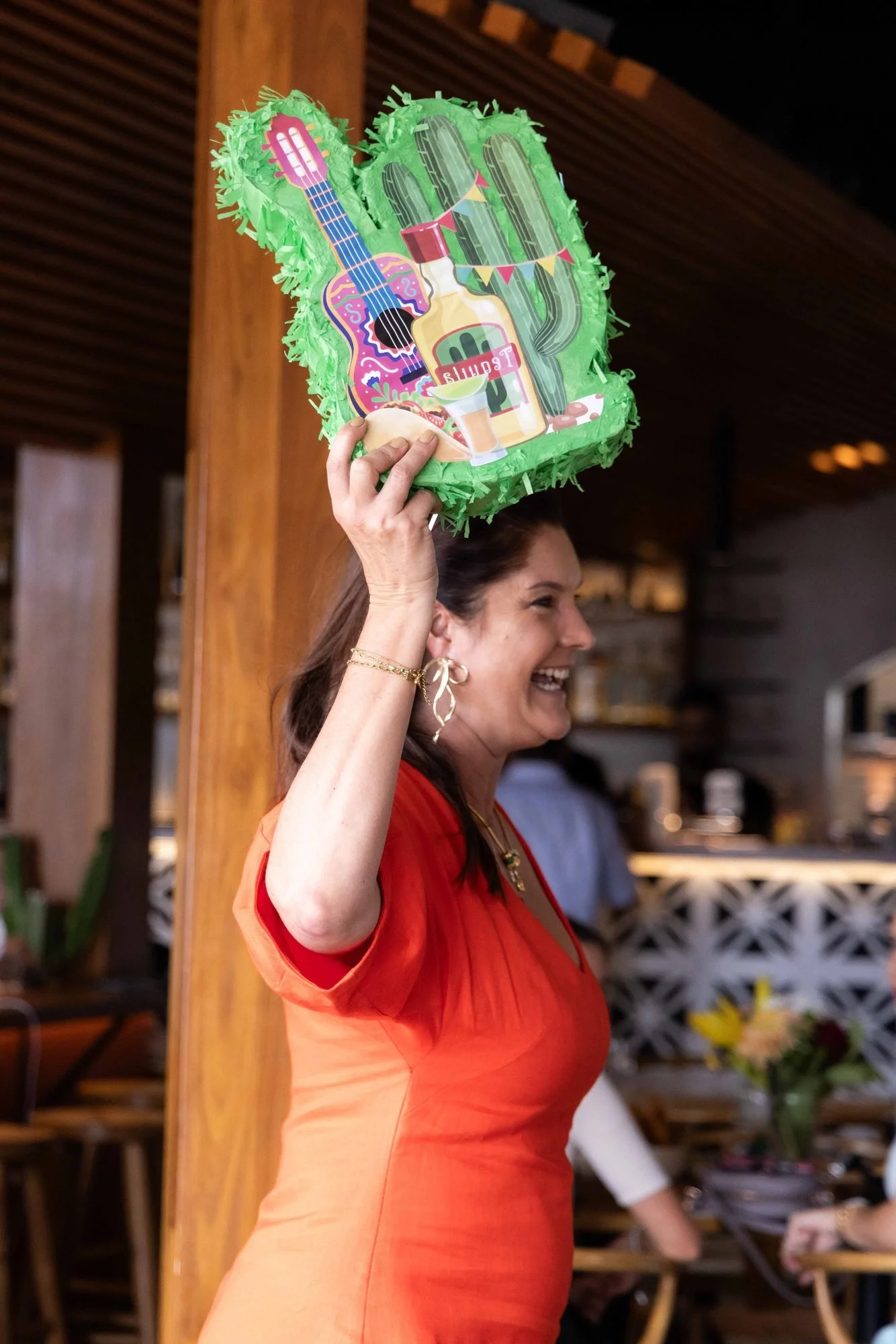 A smiling guest holding up a colourful cactus prop at The Rolling Lunch 2026