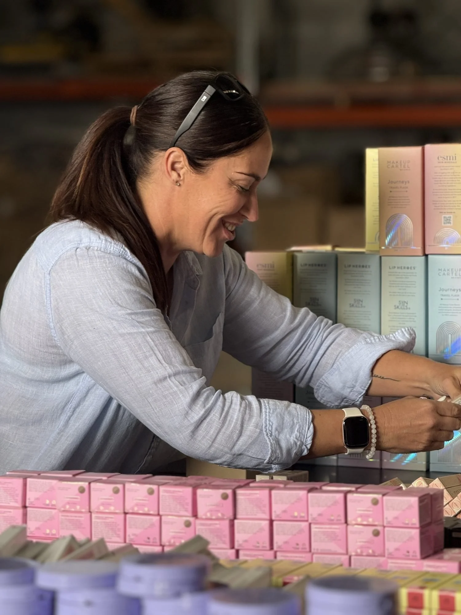 A volunteer smiling as she packs items for the campaign packs