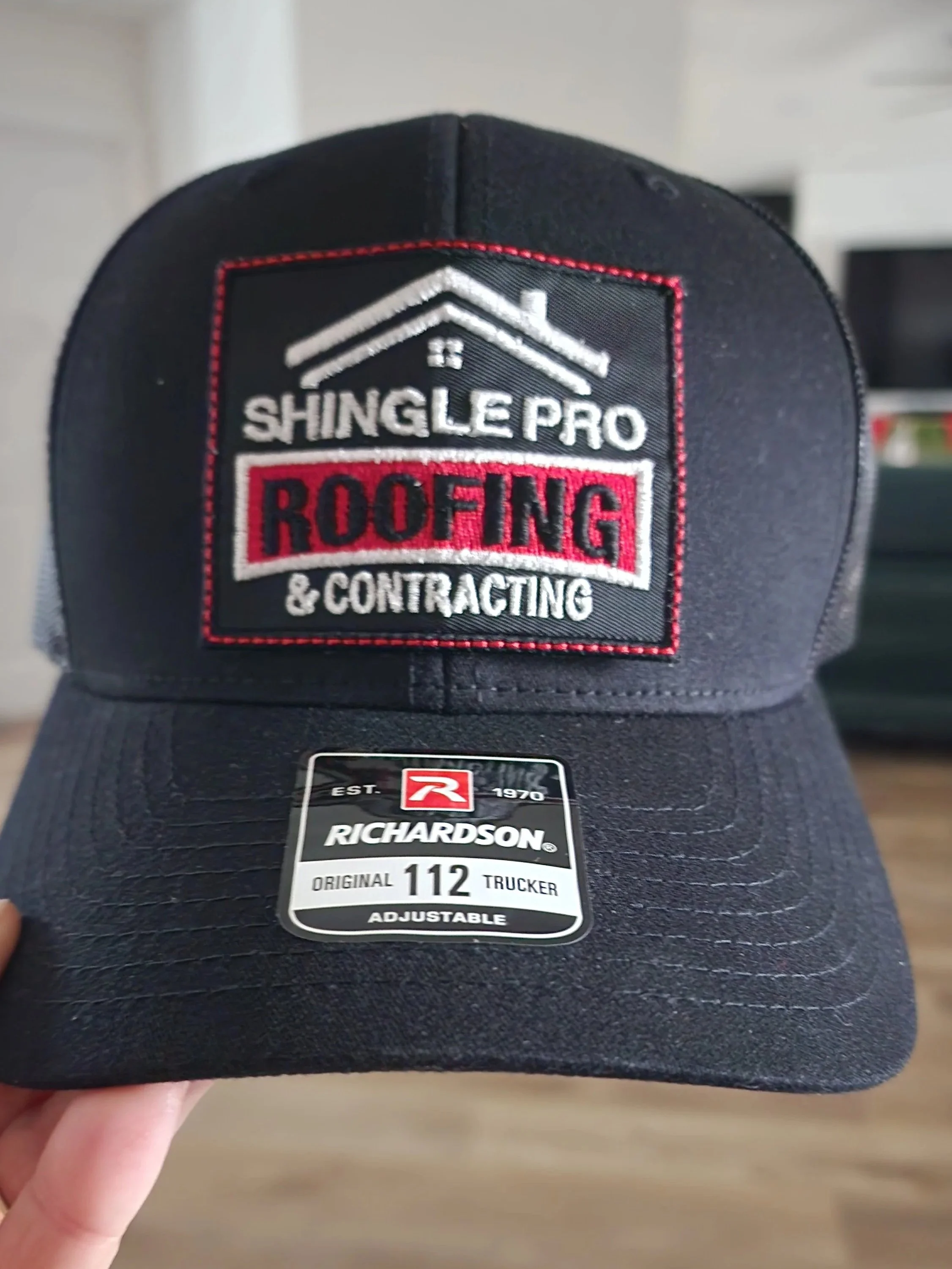 black trucker hat with embroidered patch with a business logo