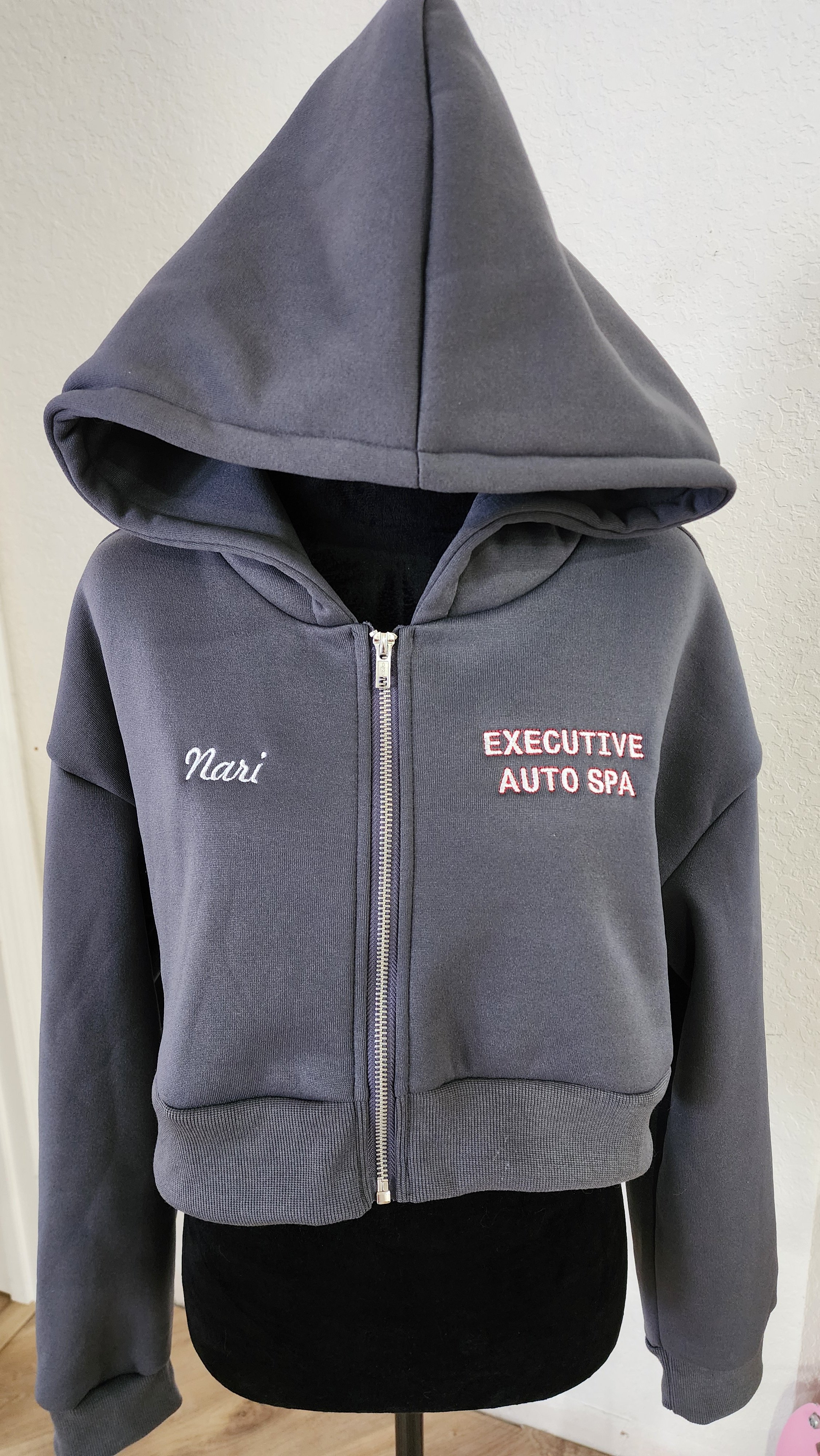Gray zip-up hoodie with a hood, embroidered with the name "Nari" on the left chest and "EXECUTIVE AUTO SPA" on the right chest.