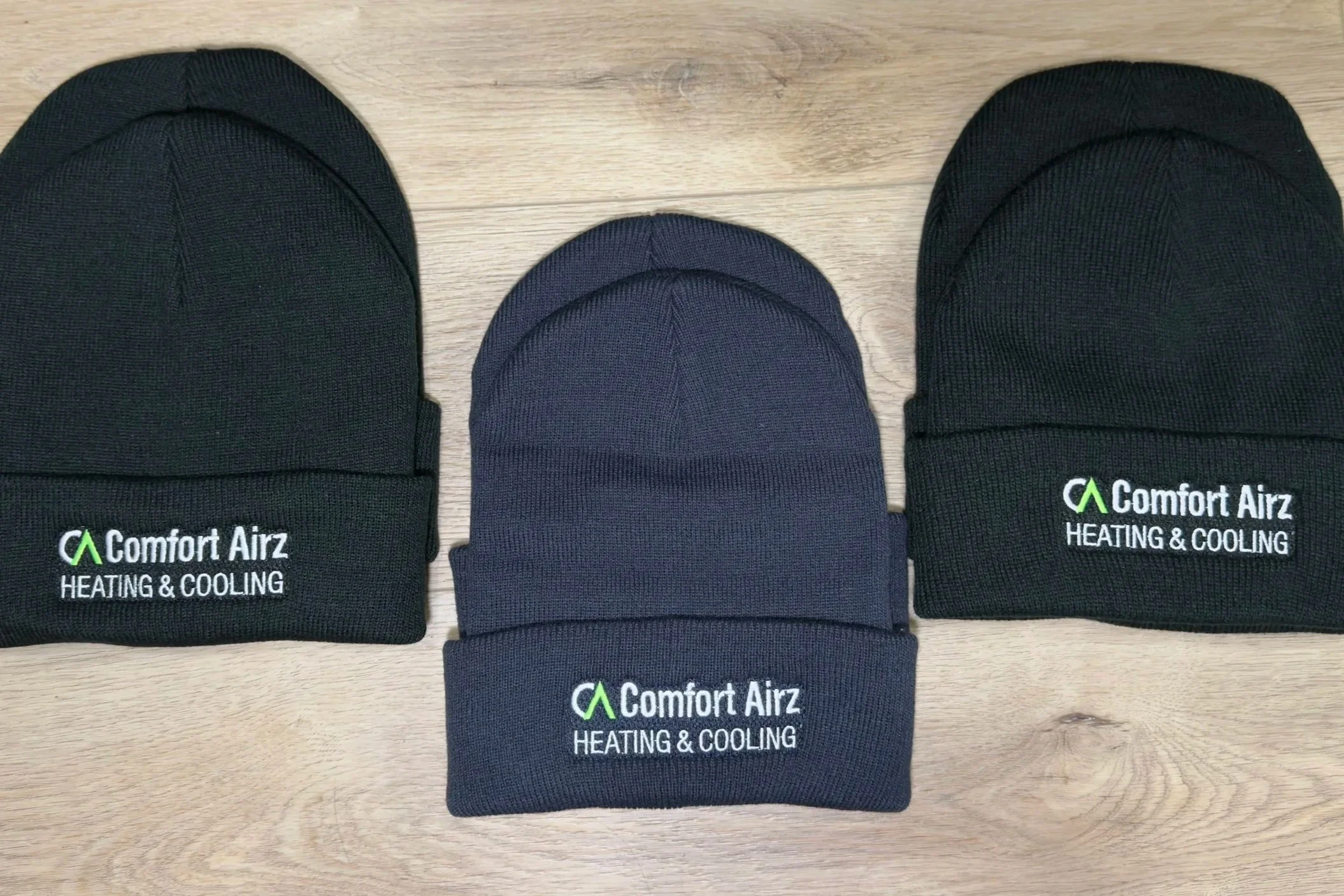 embroidered black and navy blue beanies with a business logo