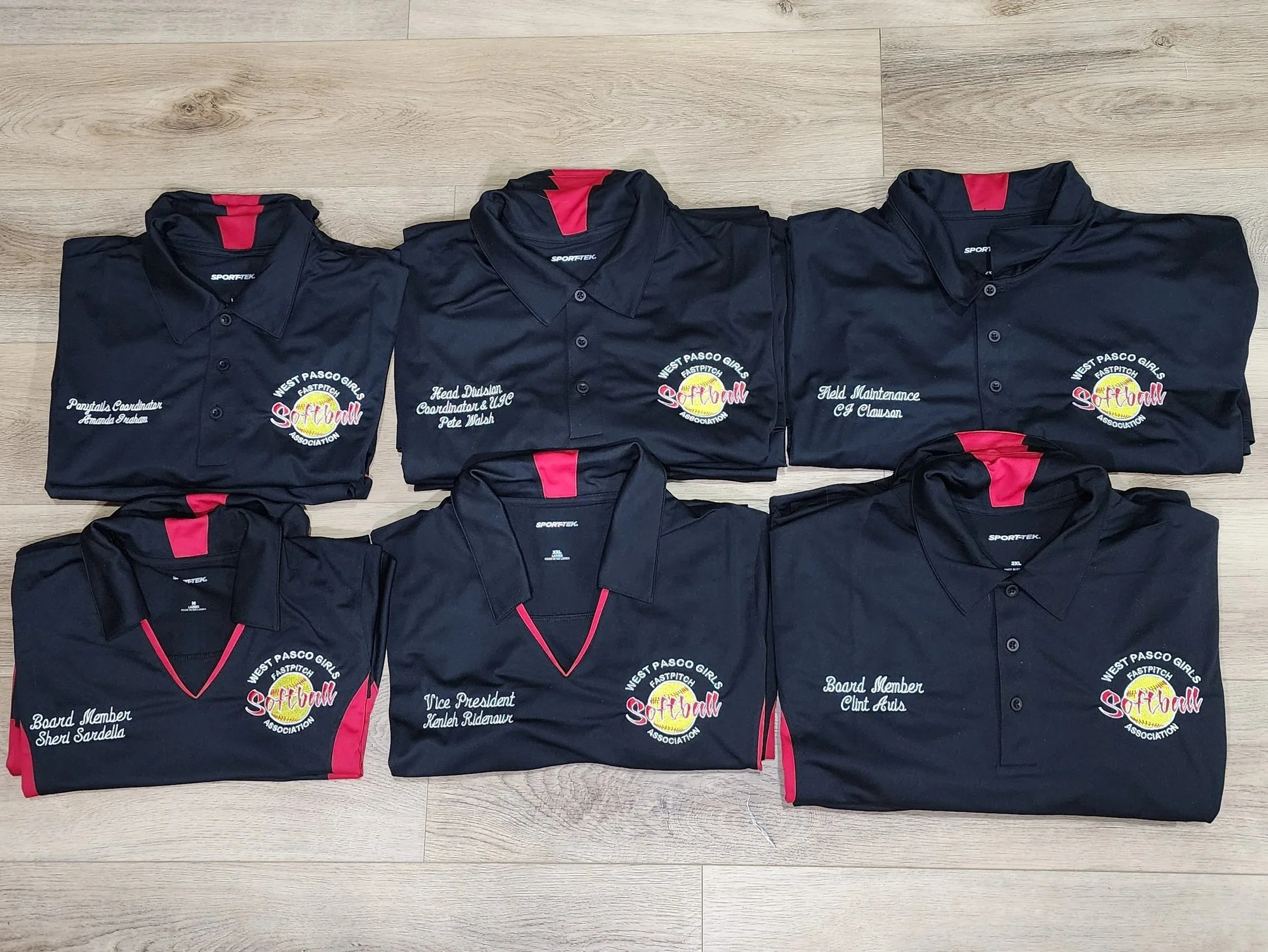 black polo shirts with red detail and embroidered business logo on a left chest and a name and title on the right chest