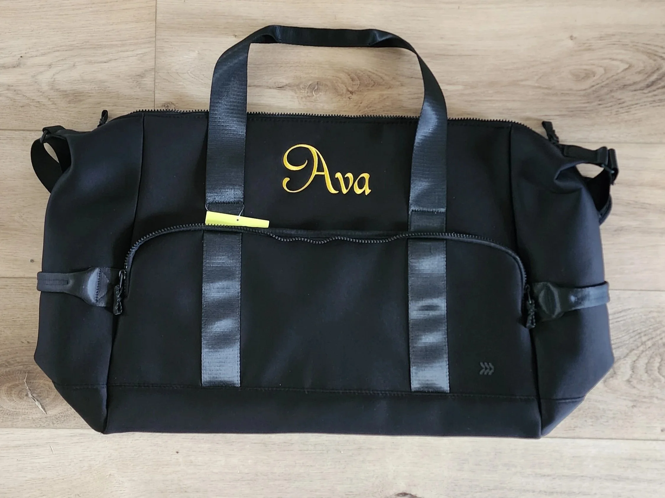 black duffel bag with name embroidered in front in gold