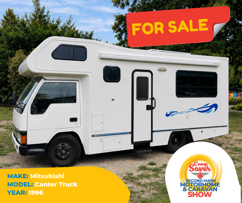 A white Mitsubishi Canter truck with blue graphic decals parked outdoors with a red and yellow "For Sale" sign on top and a Camp Saver Second-Hand Motorhome & Caravan Show logo at the bottom right.