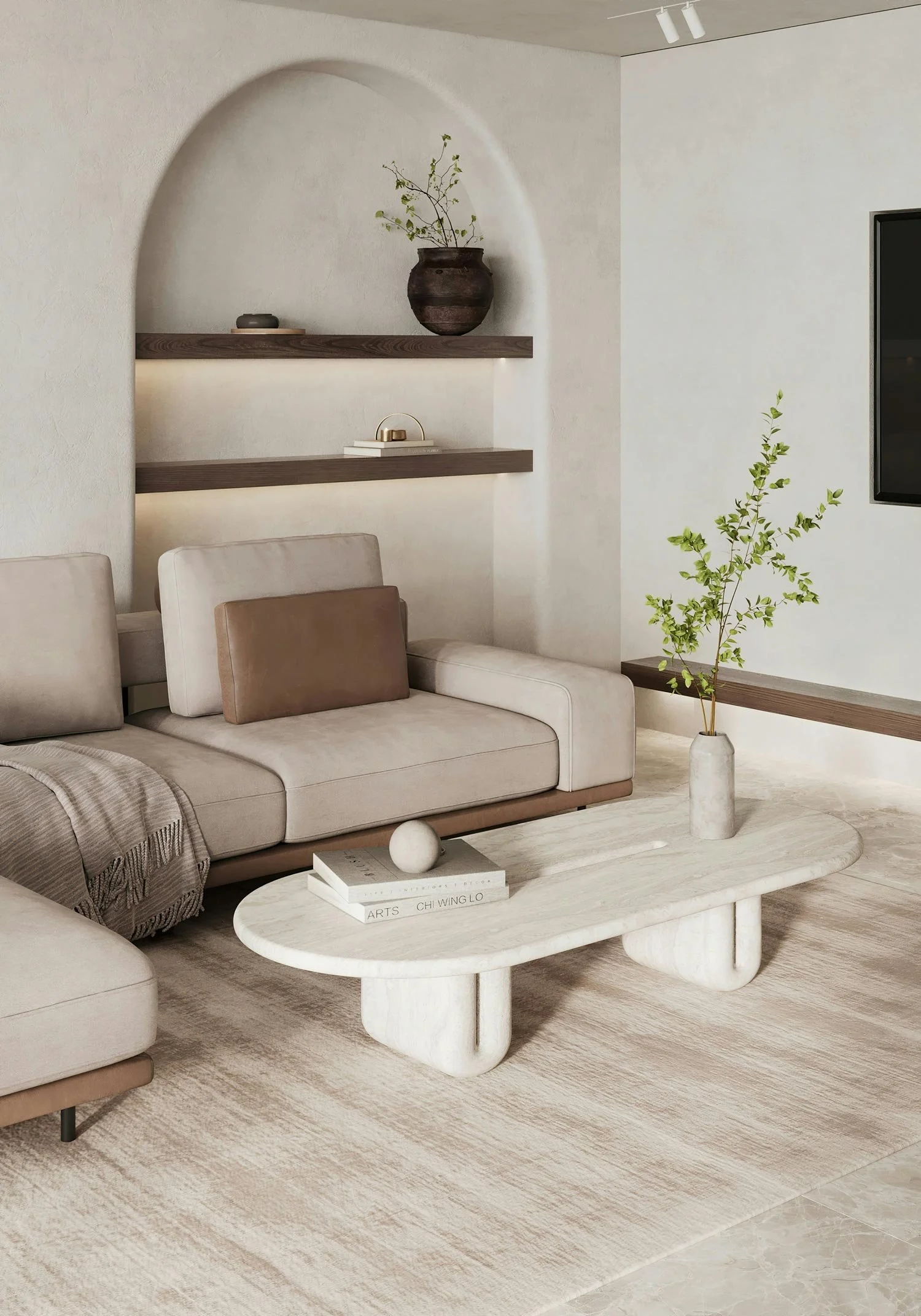 A modern living room with a beige sofa, a white marble coffee table, and a textured area rug. The decor includes a tall vase with green branches, a small stack of books, and a round decorative object. The wall features wooden shelves with minimalist decor and a framed wall art.