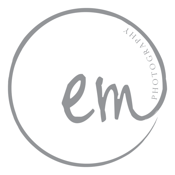 Logo with a circle outline containing the text 'em' in the center and 'PHOTOGRAPHY' along the top curve.
