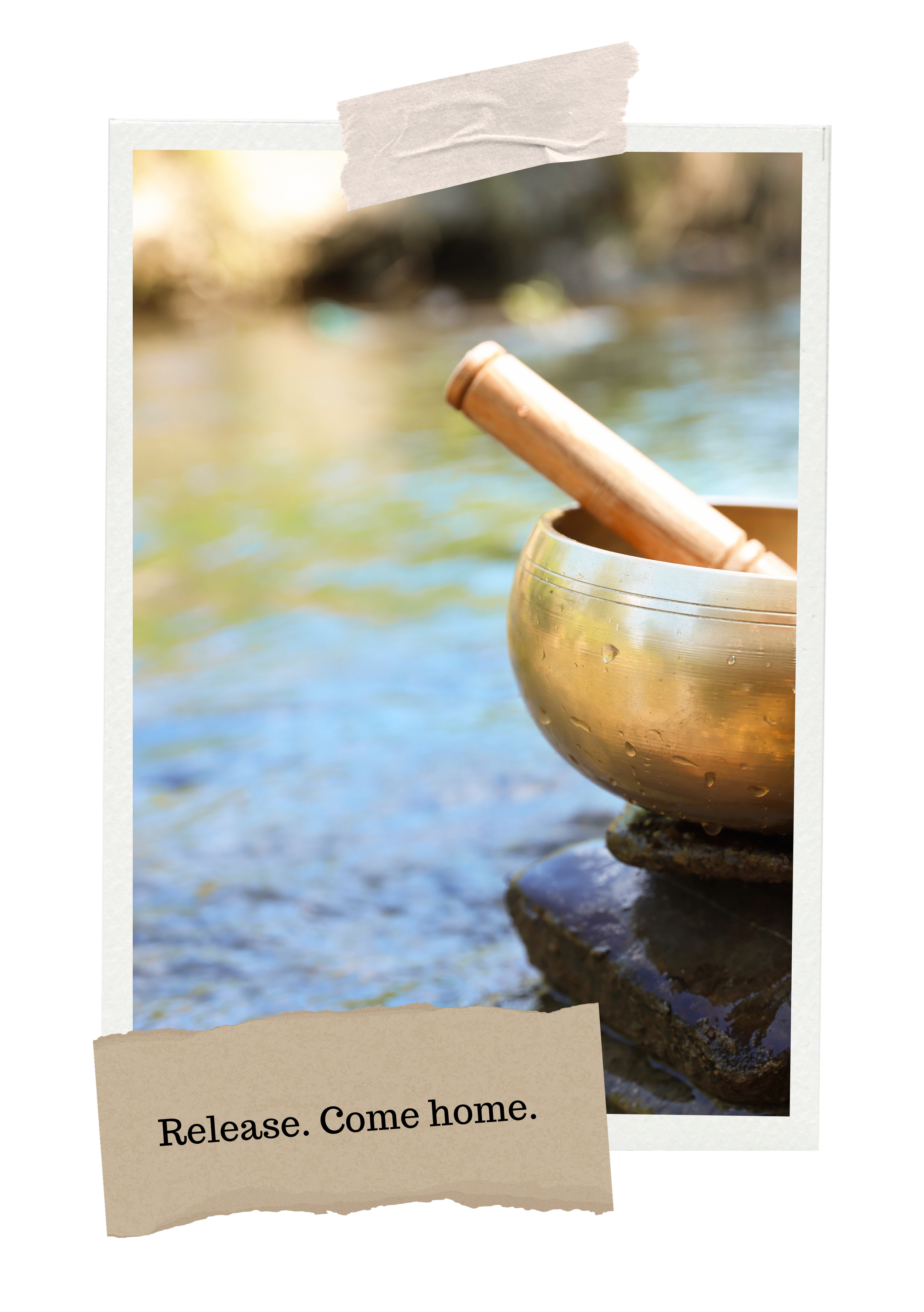 A brass singing bowl with a wooden mallet inside, placed on a rock by a river. The background shows blurred water and trees with sunlight. Text overlay says, "Release. Come home."