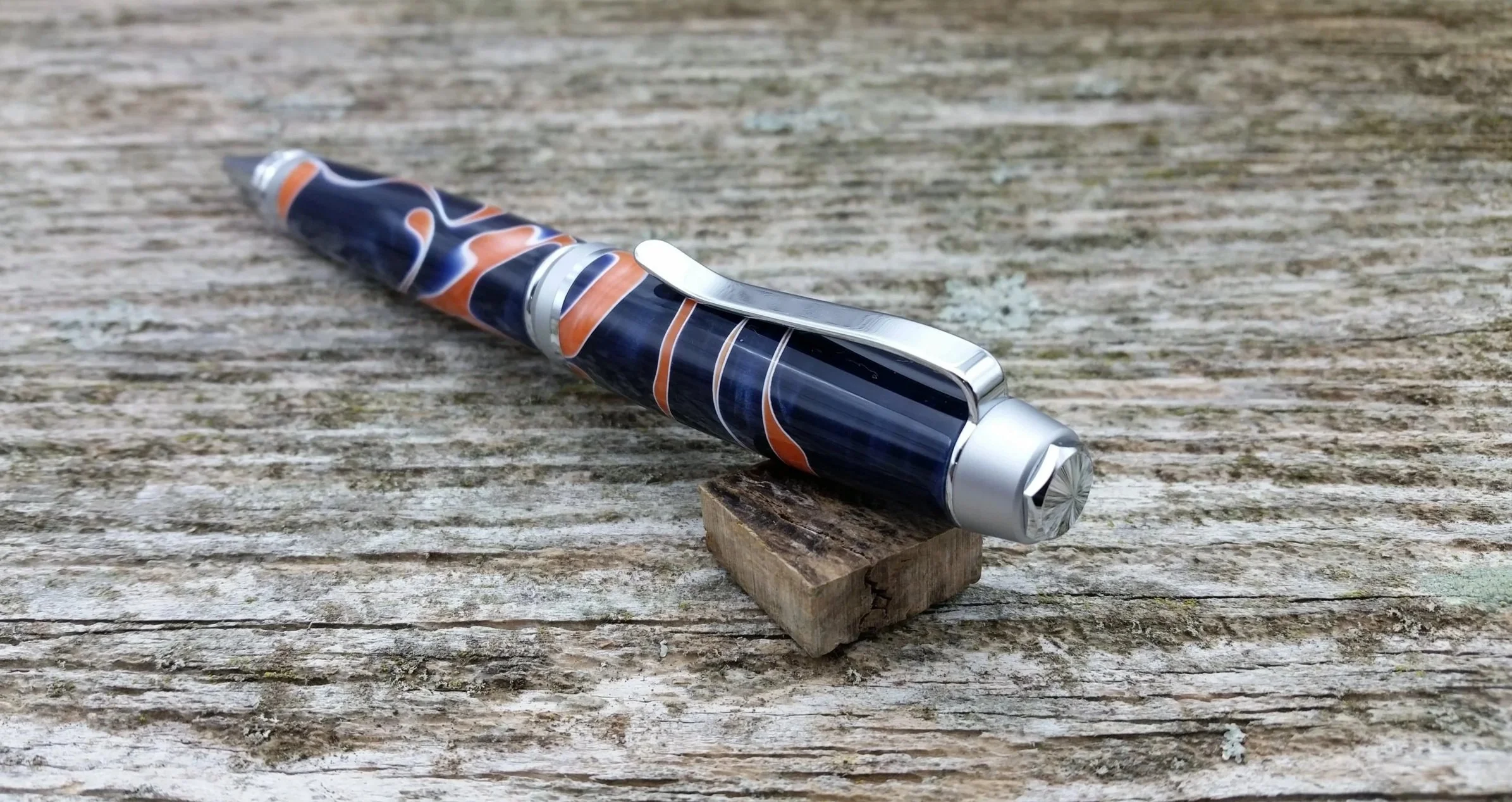 Parus Pen ballpoint twist pen with chrome hardware and blue, orange, white resin end view