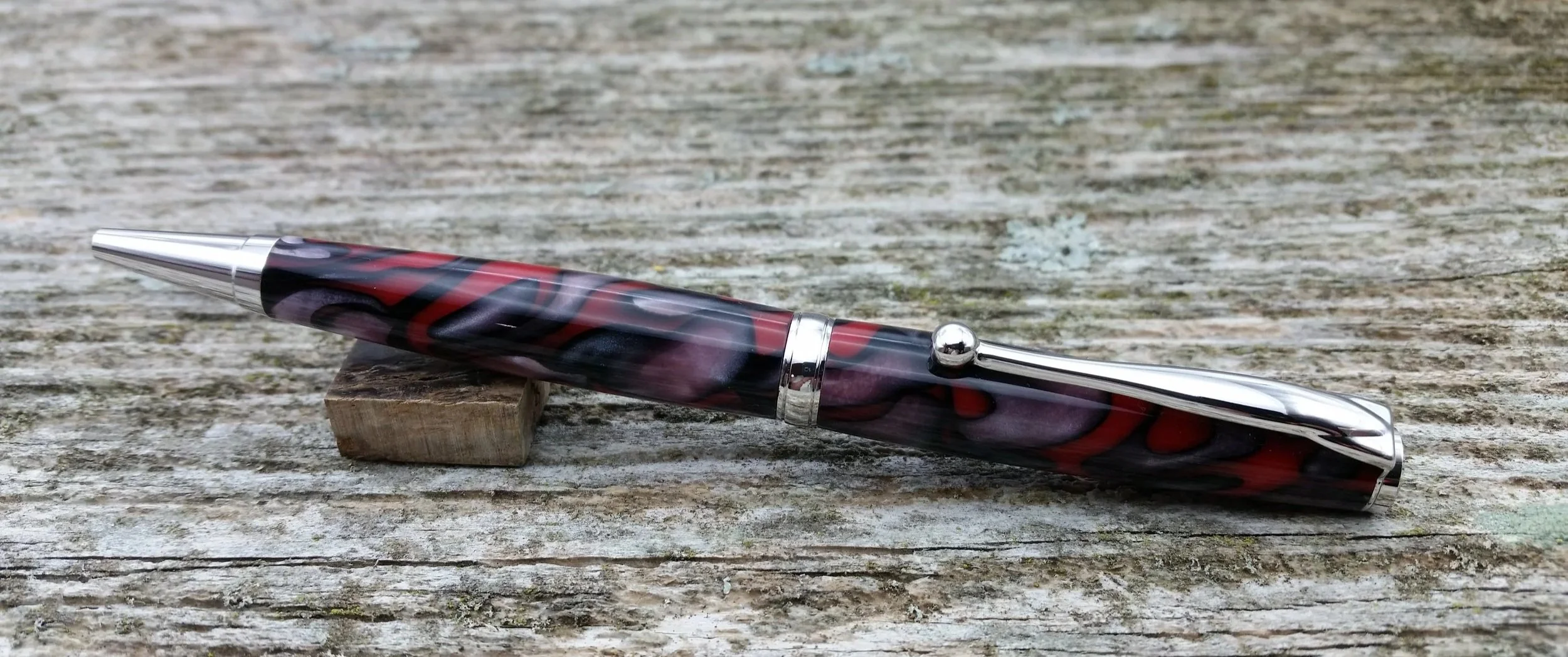 Parus Pen ballpoint twist pen with rhodium hardware and red swirled resin clip view