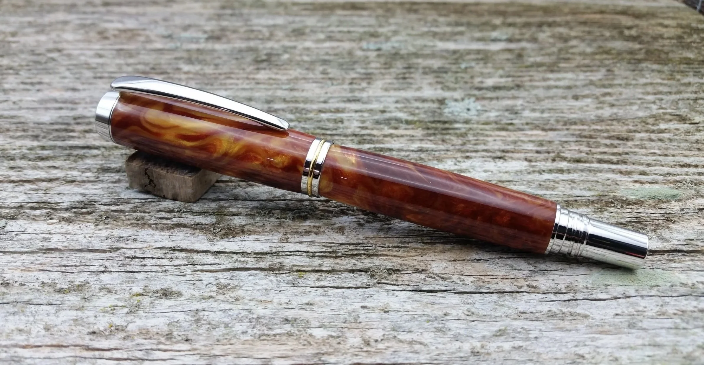 Parus Pen rollerball pen with rhodium and gold hardware and swirled amber resin clip view