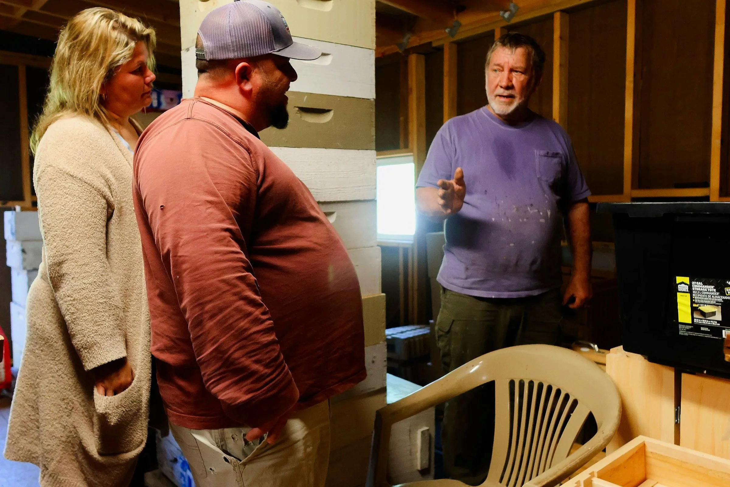 Tom Hankins speaks with David Perez and Priscilla Brozq about beekeeping equipment in Danielsville, Georgia, on April 14, 2025. Haskins uses his experience to educate and advise newer beekeepers on the process of beekeeping.