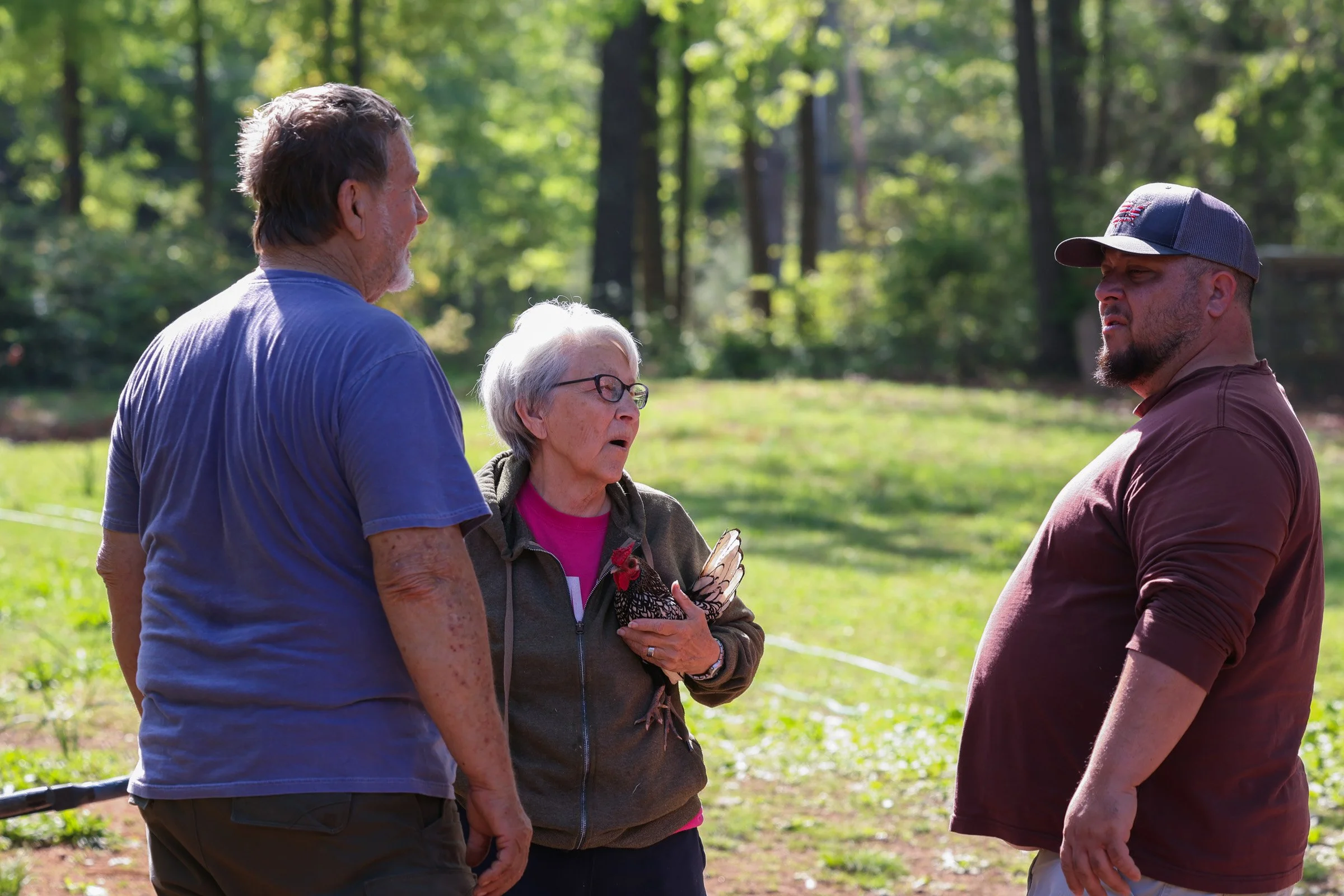 Tom Hankins and his wife April Hankins, speak with David Perez about beekeeping equipment in Danielsville, Georgia, on April 14, 2025. Haskins uses his experience to educate and advise newer beekeepers on the process of beekeeping. 