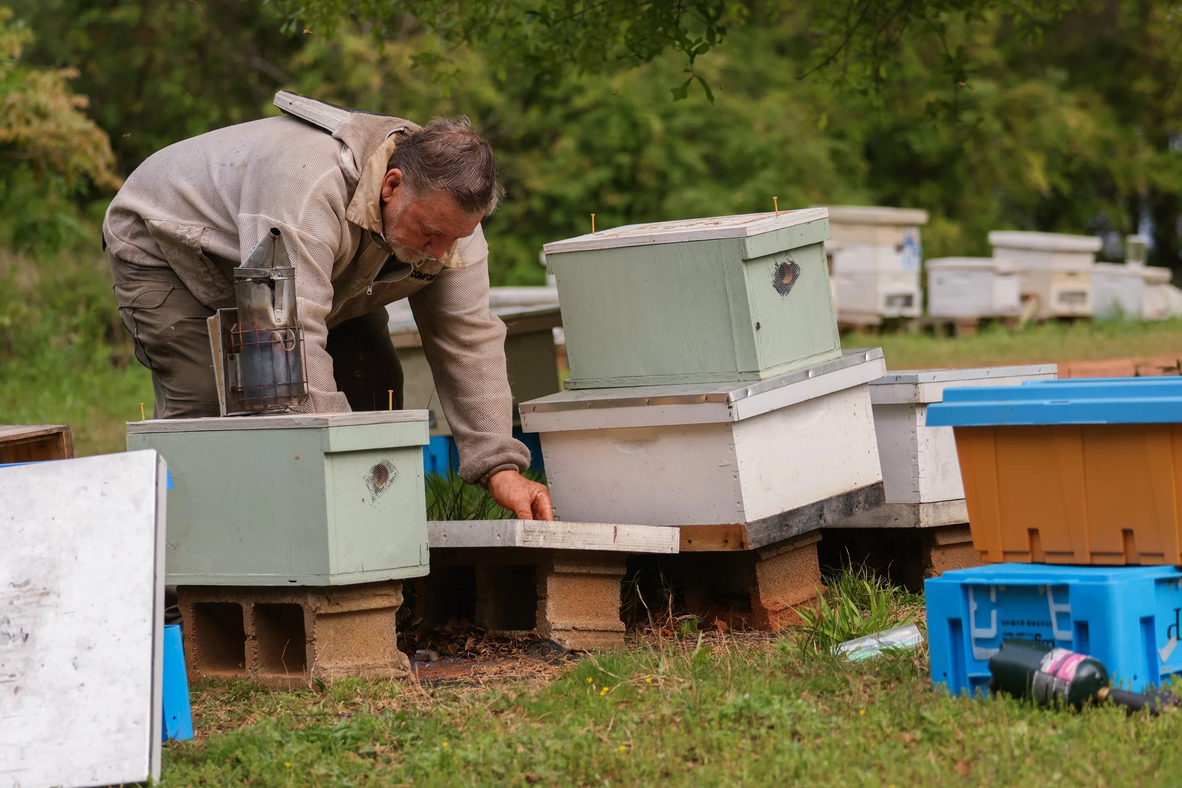 Tom Hankins tends to his beehives in Danielsville, Georgia, on April 14, 2025. He checks the hives weekly, ensuring the bees are thriving.
