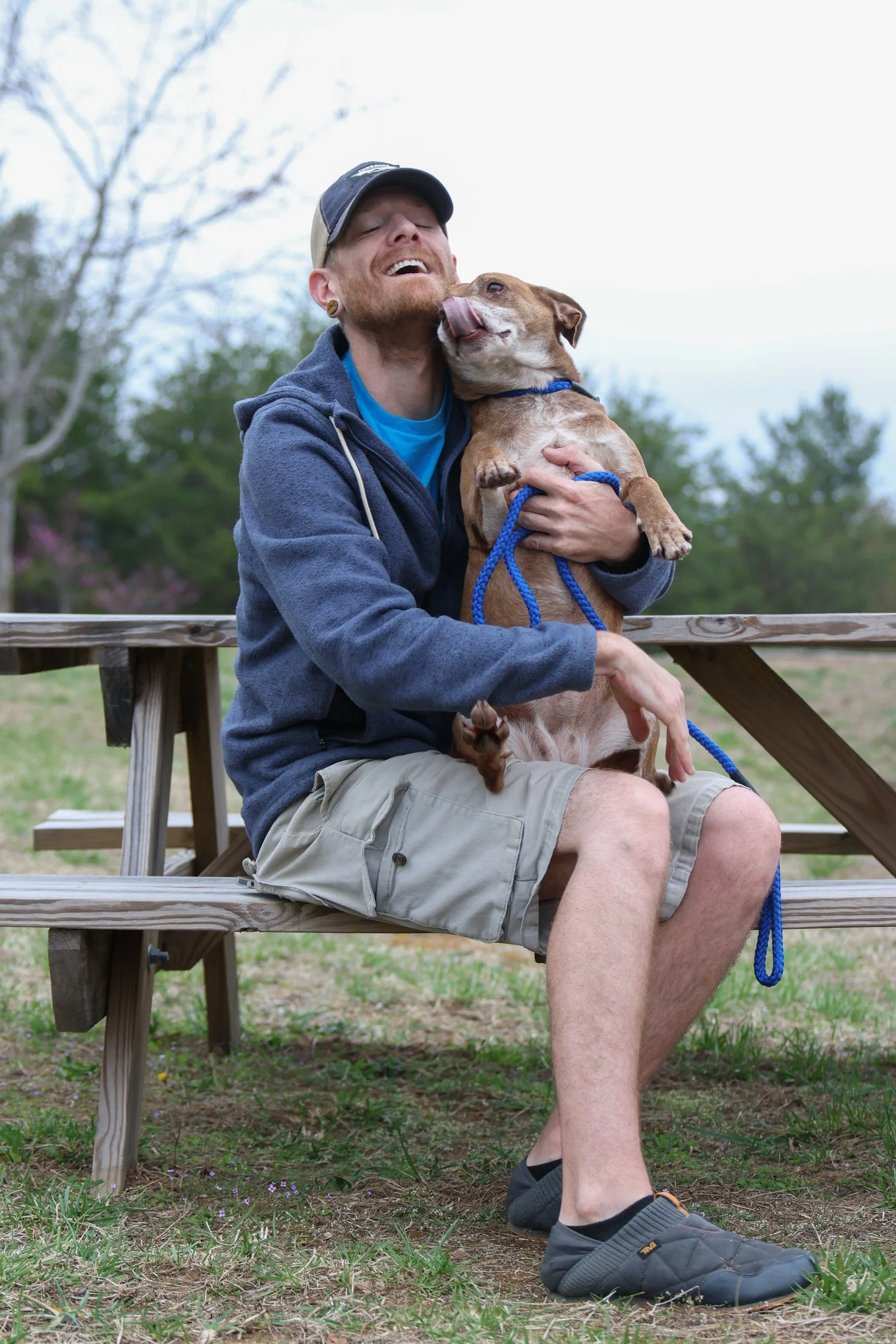 Rabun Paws 4 Life Humane Society Employee Everett Lampros poses for a portrait with “Jackie,” an American Pitbull, outside of the Rabun Paws 4 Life humane shelter in Tiger, Georgia, on Saturday, March 15, 2025. Everett Lampros serves as the volunteer