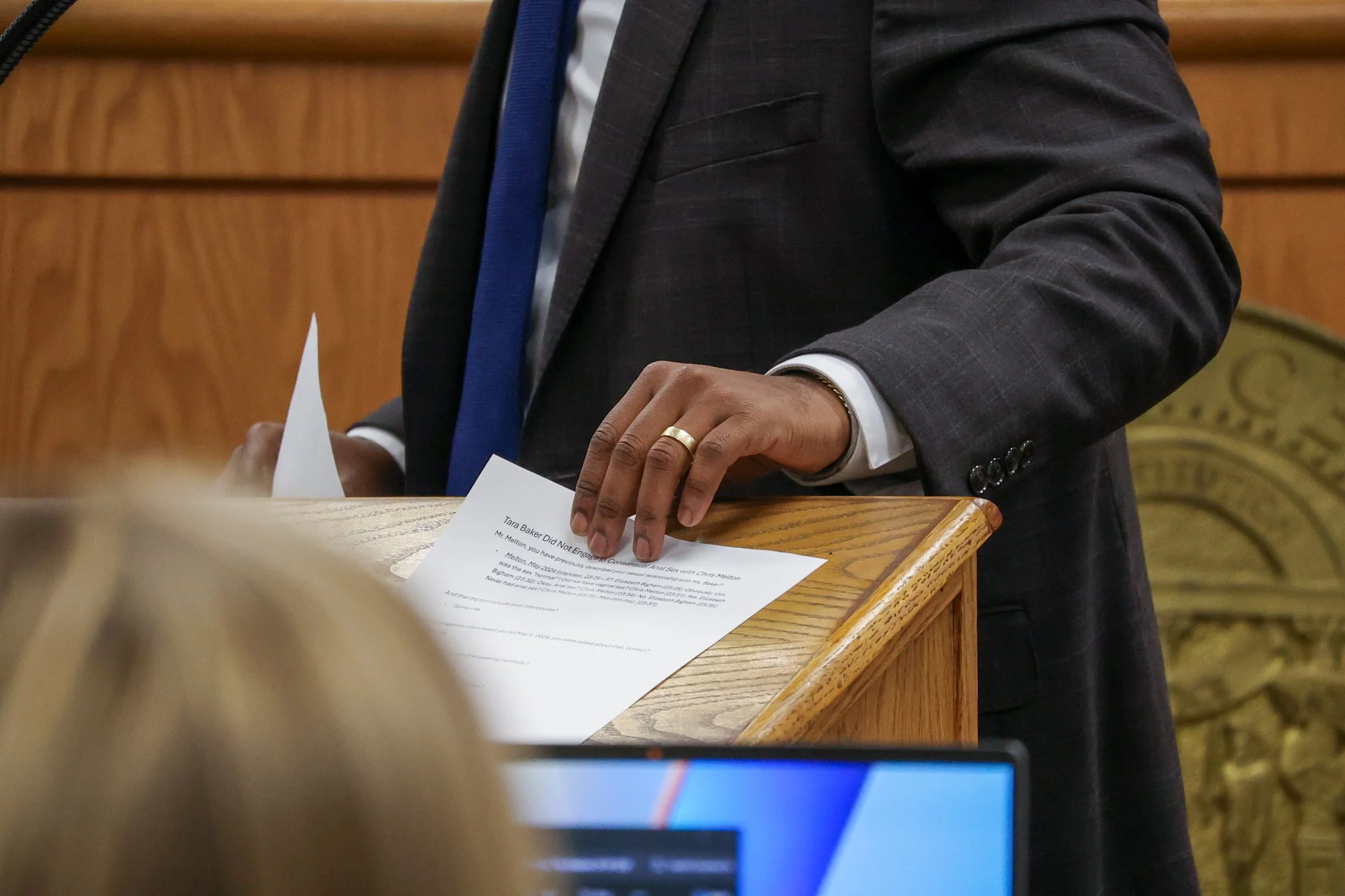Defense Attorney Ahmad Crews grabs paper off a stand during the Tara Baker murder trial at the Athens-Clarke County Courthouse in Athens, Georgia, on Monday, Feb. 9, 2026. In January 2001, Tara Baker, a 23-year-old UGA law student, was killed in her 
