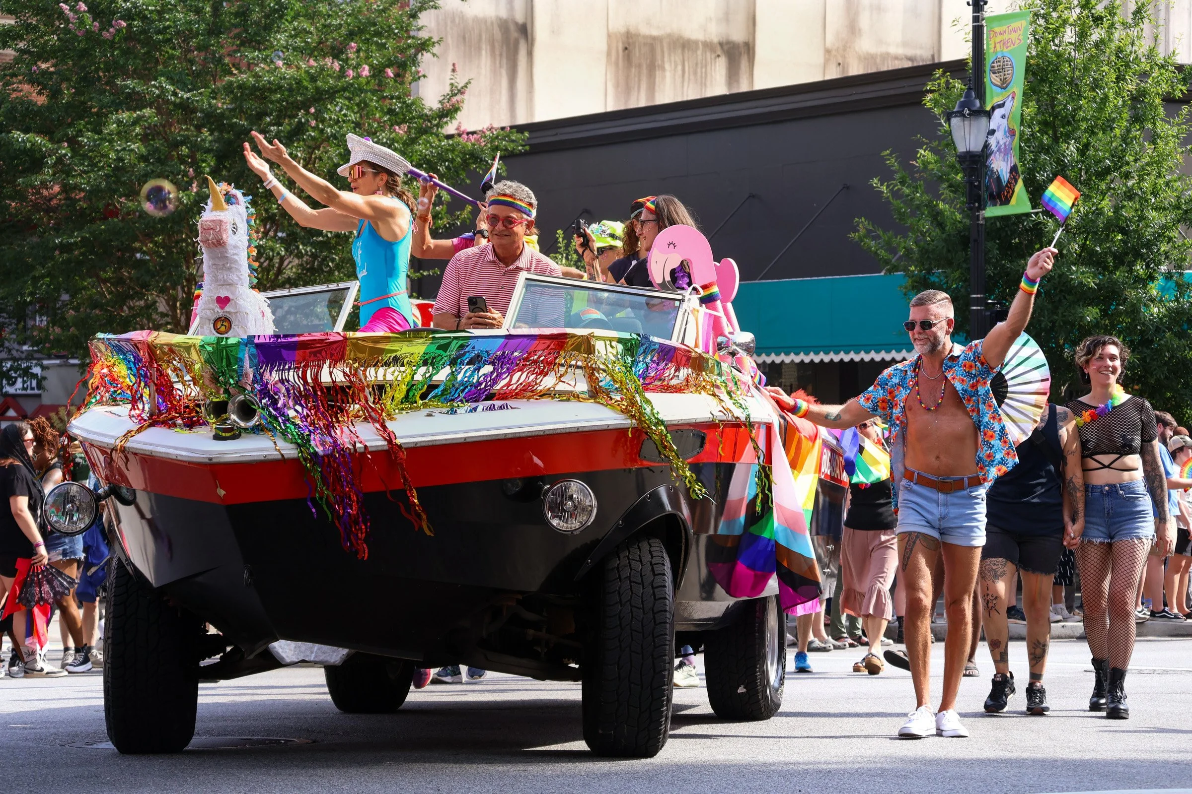 Participants wave to attendees during the 2025 Athens Pride Parade, hosted by the Athens Pride and Queer Collective, in downtown Athens, Georgia on Saturday, June 7, 2025. The parade looks to celebrate and uplift the LBGTQ+ community, while also brin