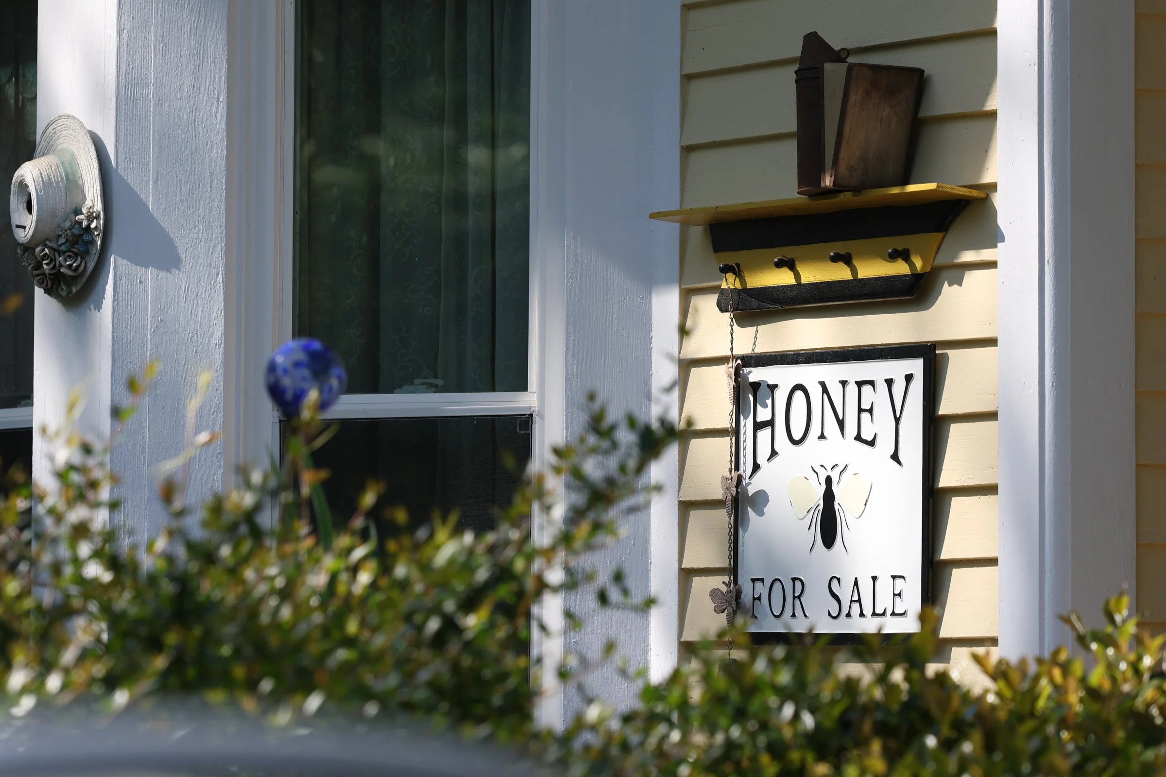 A sign that reads “Honey for sale” hangs on Tom Hankins front porch in Danielsville, Georgia, on April 14, 2025. Tom Hankins offers raw honey, a product he has sold at the market for over seven years, highlighting its health benefits.
