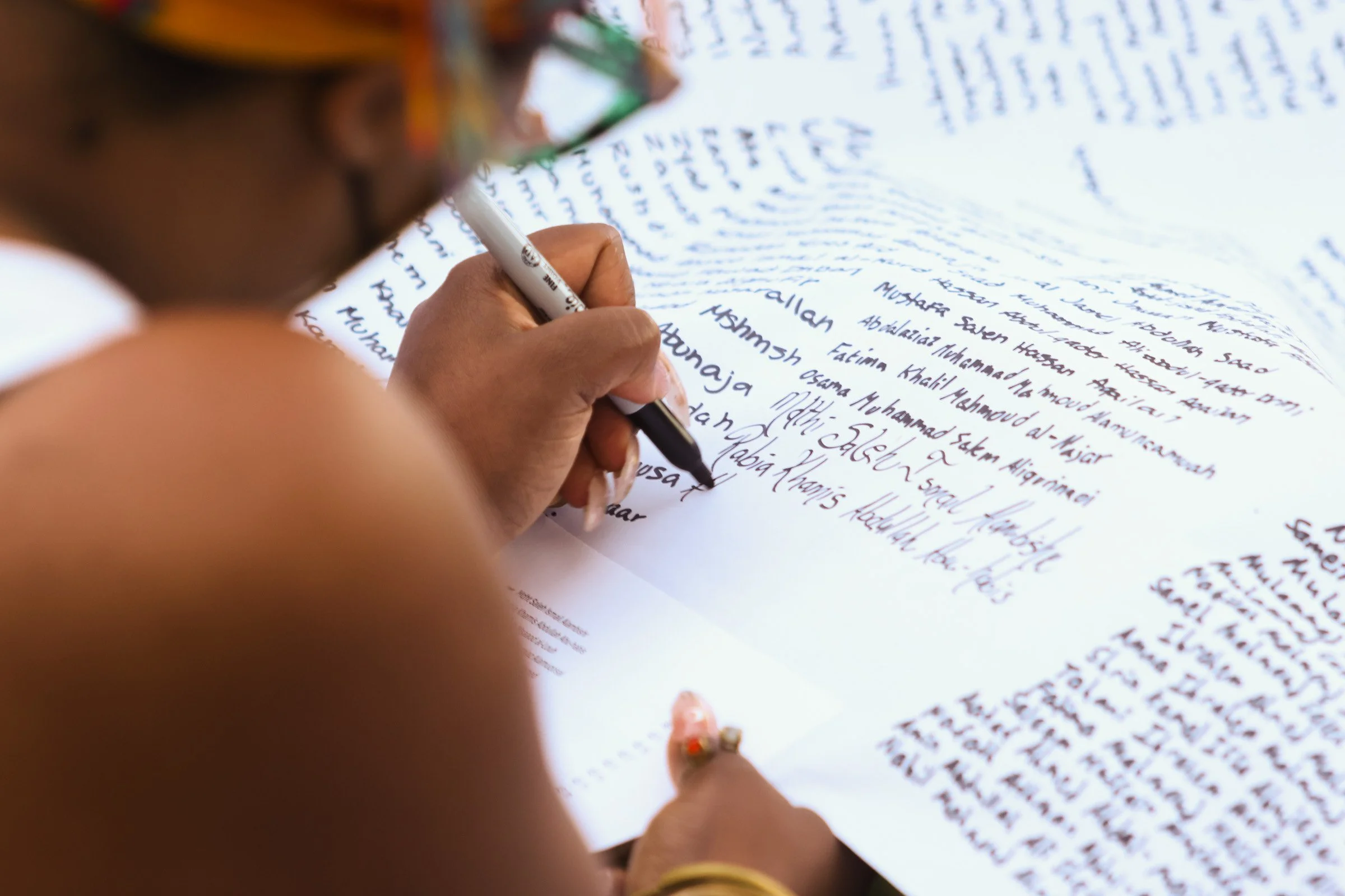 Memorial attendee writes the names of those who lost their lives in Palestine during the Fight For Our Rights memorial service at the University of Georgia’s North Quad on Oct. 25, 2024. The Young Democratic Socialists of America held the memorial to