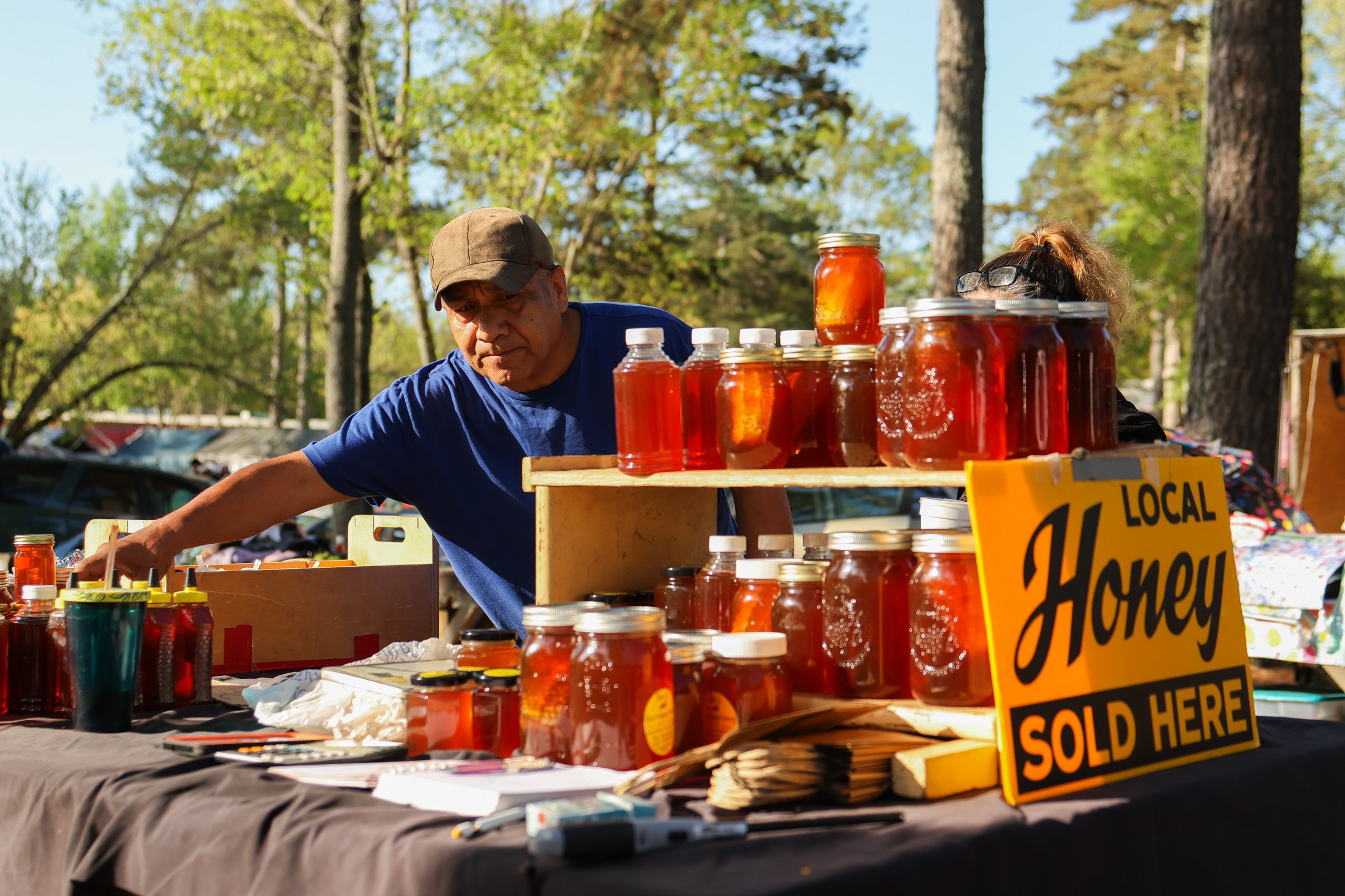 Marcelo Palle browses jars of raw honey at Tom Hankins's stand at the J&J Flea Market in Athens, Georgia, on April 5, 2025. Marcelo has been a consistent customer at Tom's stand. 
