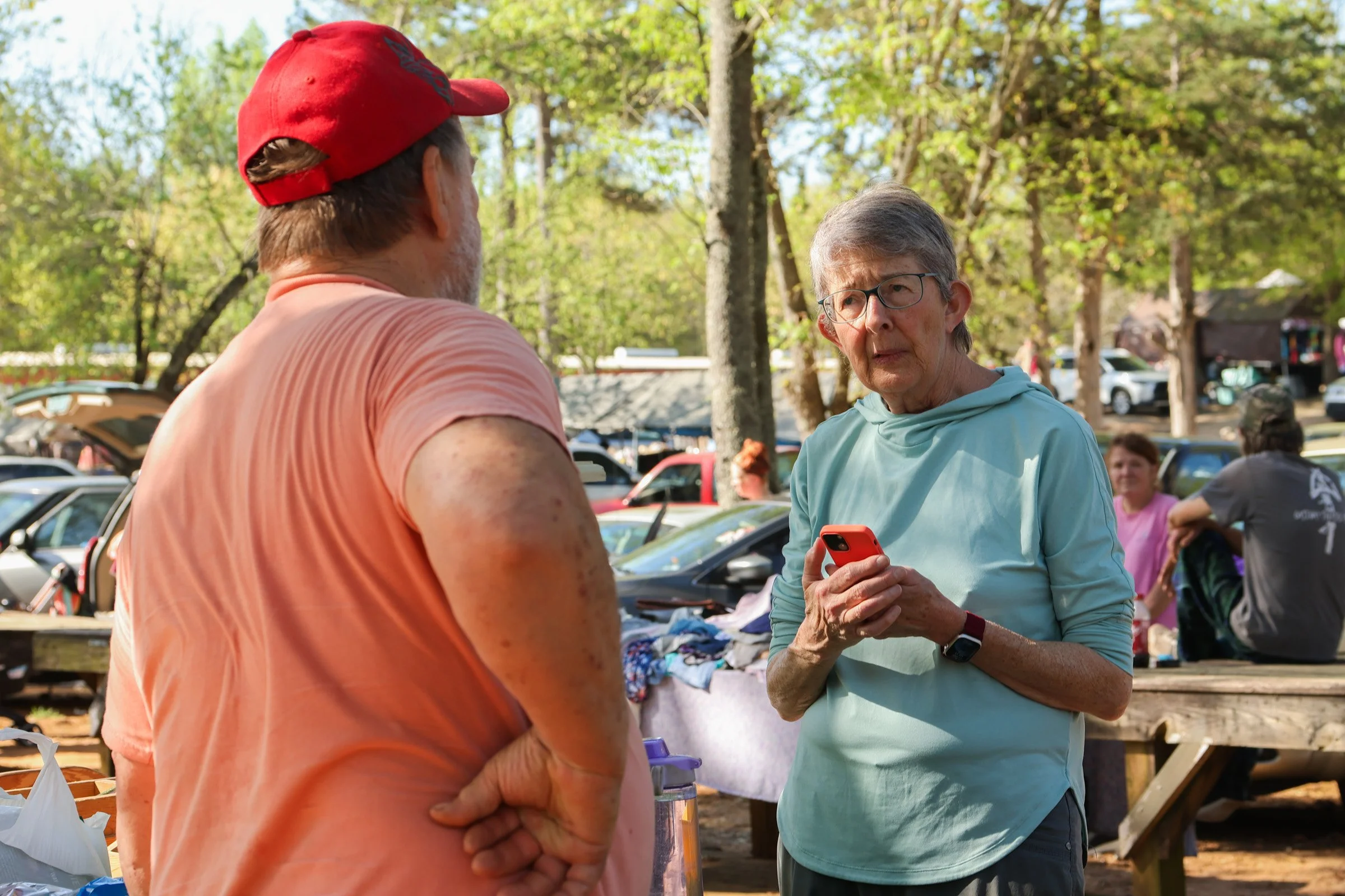 Tom Hankins speaks with Eve Gallman about starting a honey bee farm at his honey stand at the J&J Flea Market in Athens, Georgia, on April 5, 2025. Hankins, who started beekeeping after assisting a youth pastor, shares advice from his experiences wit