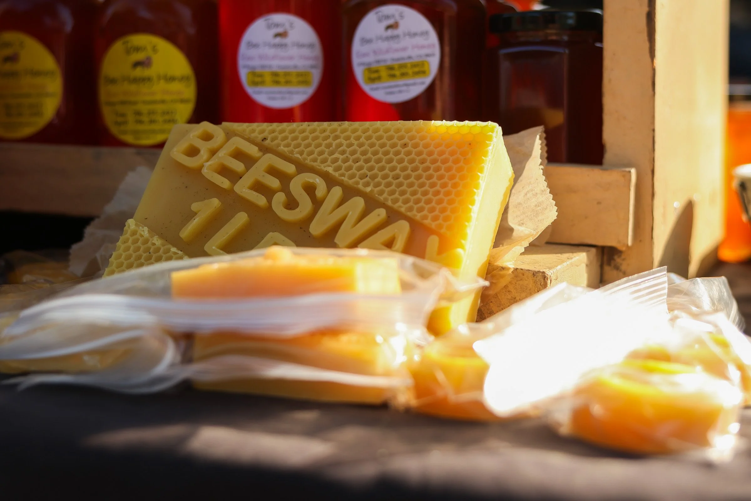 Beeswax sit on top of Tom Hankins's honey stand at the J&J Flea Market in Athens, Georgia, on April 5, 2025. Tom Hankins offers raw honey and beeswax, products he has sold at the market for over seven years, highlighting their health benefits.