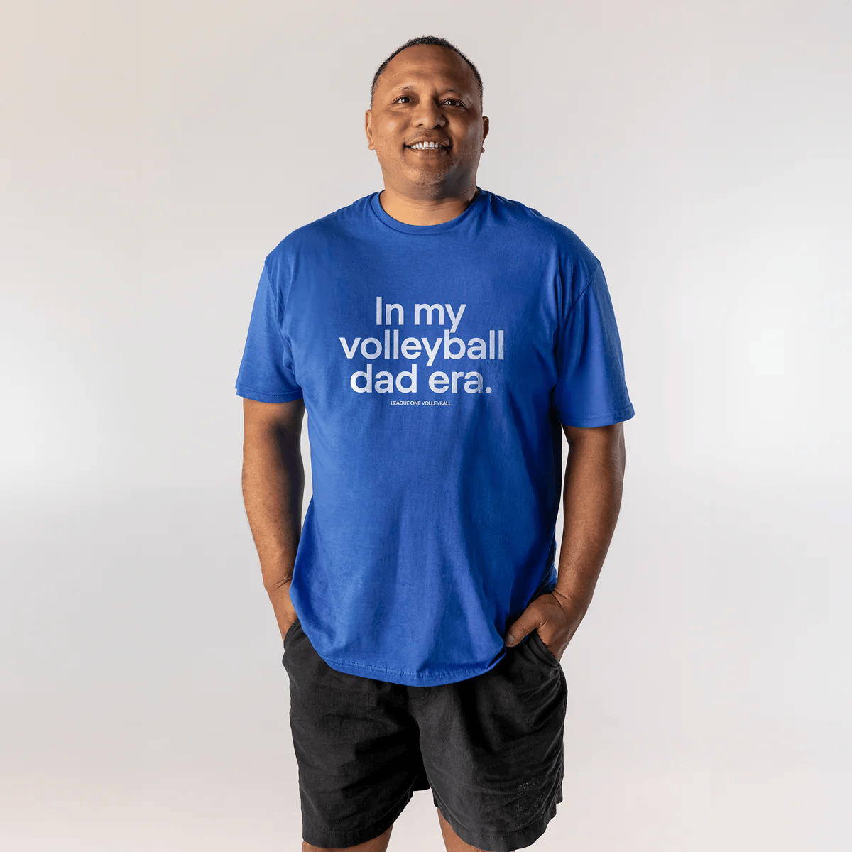 Man wearing a blue T-shirt with white text that says 'In my volleyball dad era.'