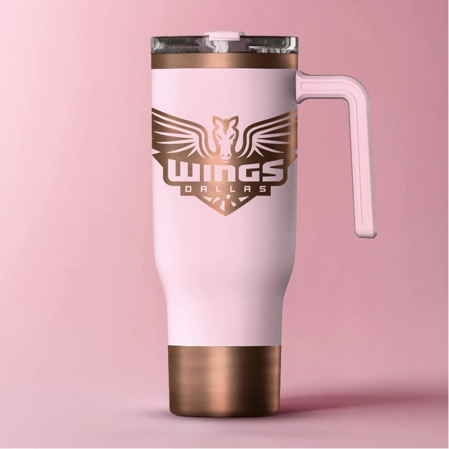 Pink tumbler with a rose gold lid and handle, featuring a logo of a winged horse head with the text "Wings Dallas" on a pink background.