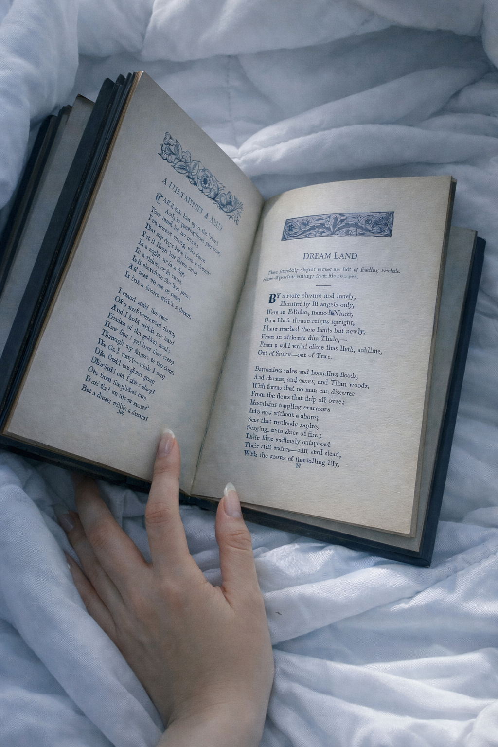 A person holding an open book with poetic verses on a white, rumpled bedsheet.