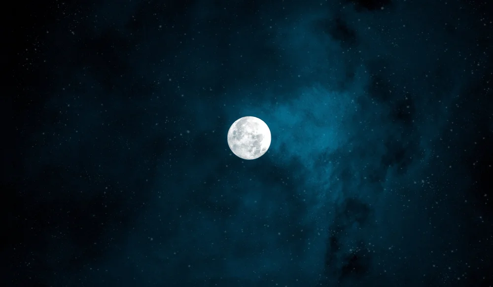 Full moon in a dark blue night sky.