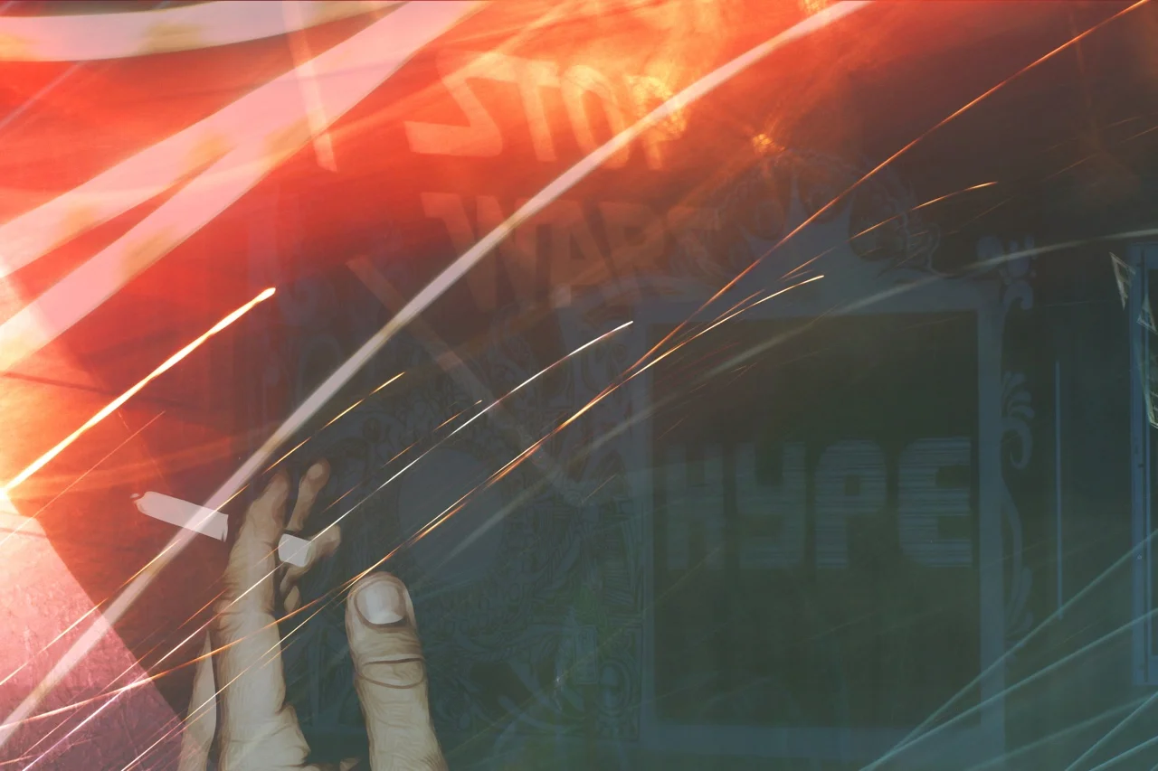 An indoor scene showing a person holding a smartphone, with colorful reflections, sparks, and a stop sign overlayed from the phone screen.