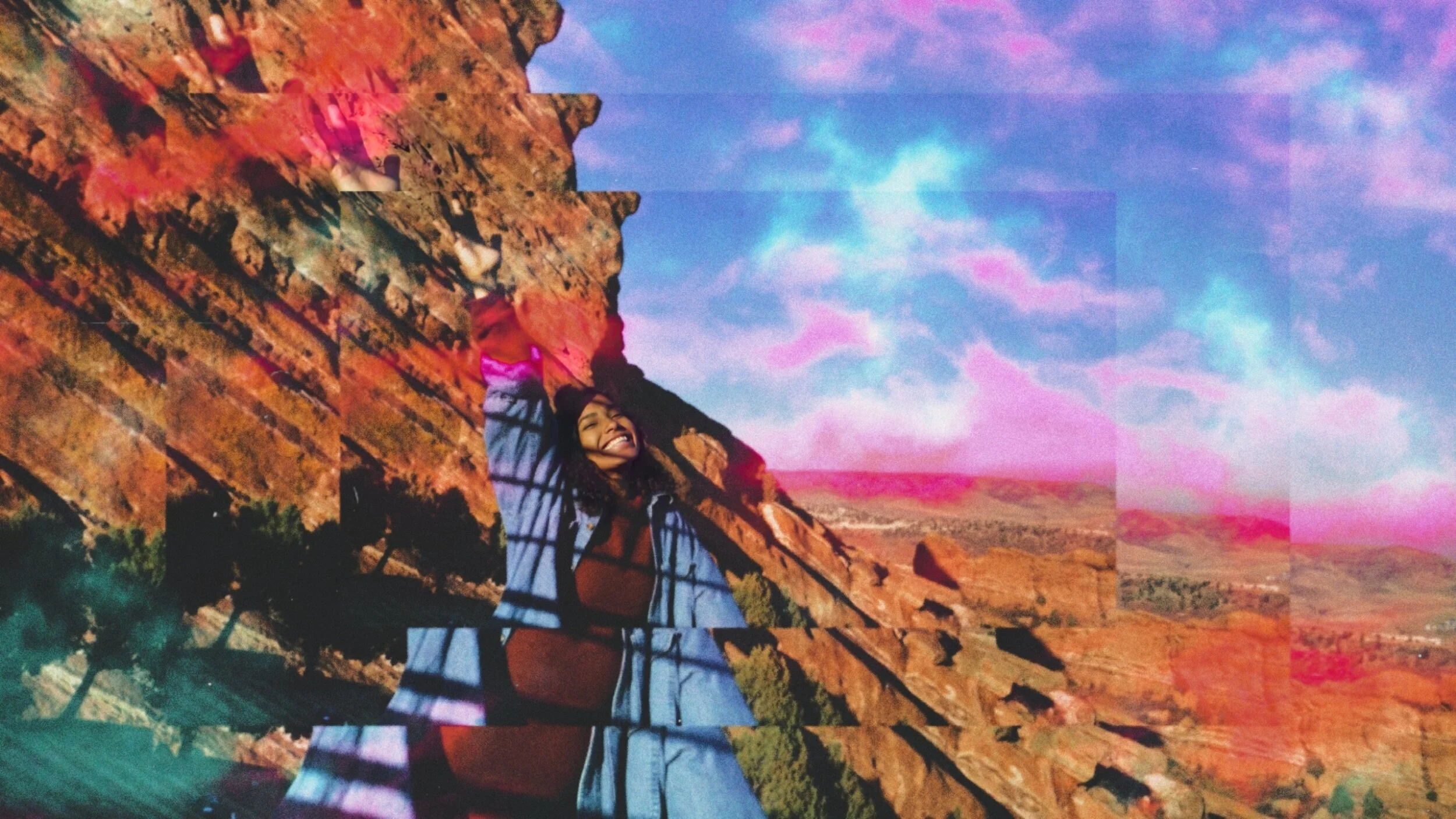 A woman smiling and standing against a rock formation in a desert landscape with colorful sky and pink clouds, with a glitch effect due to overlapping image sections.