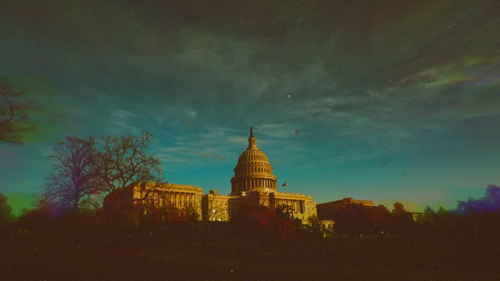 The U.S. Capitol dome at dusk under a green-tinted sky.
