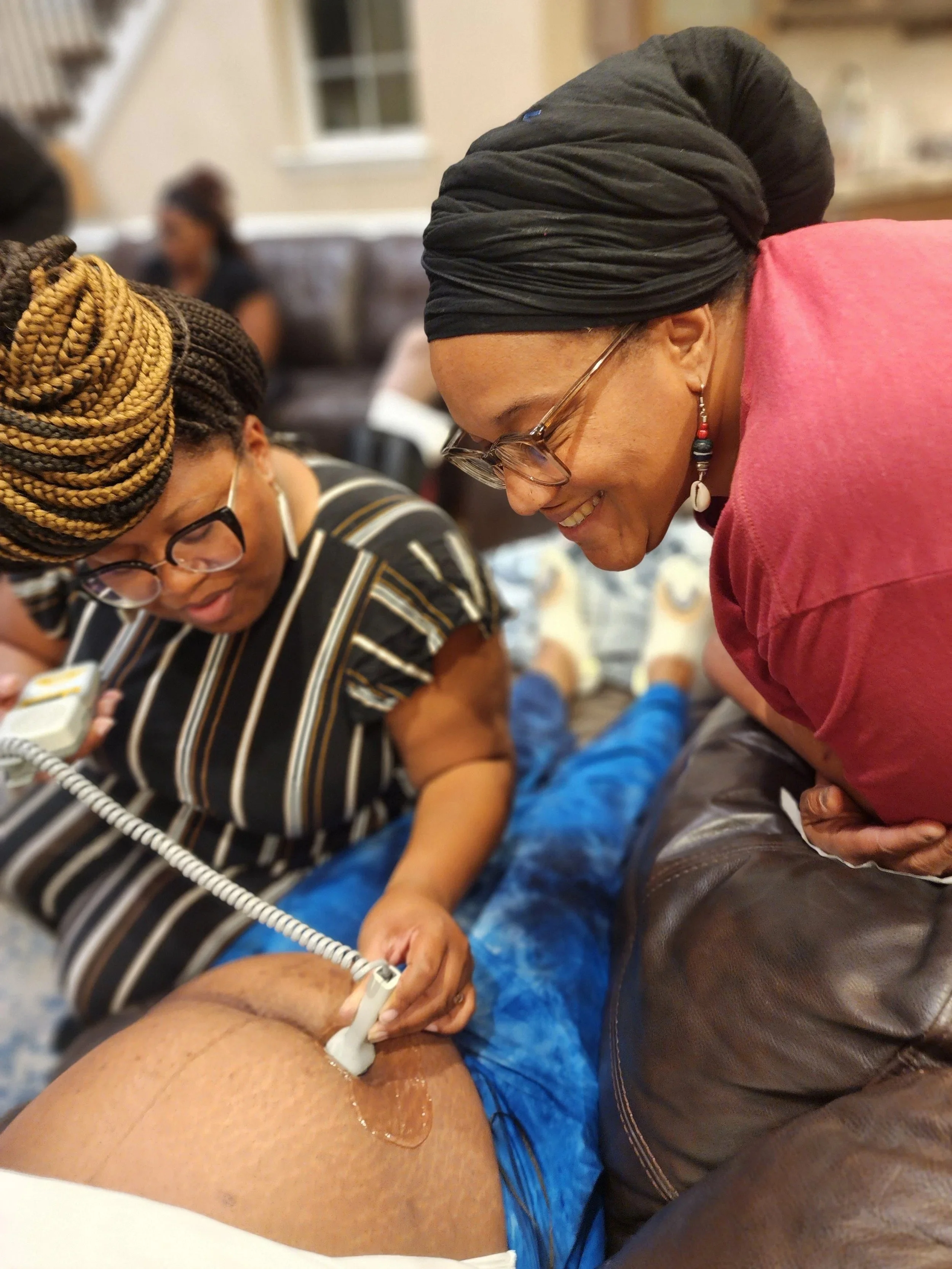 Midwife training a student to use a doppler