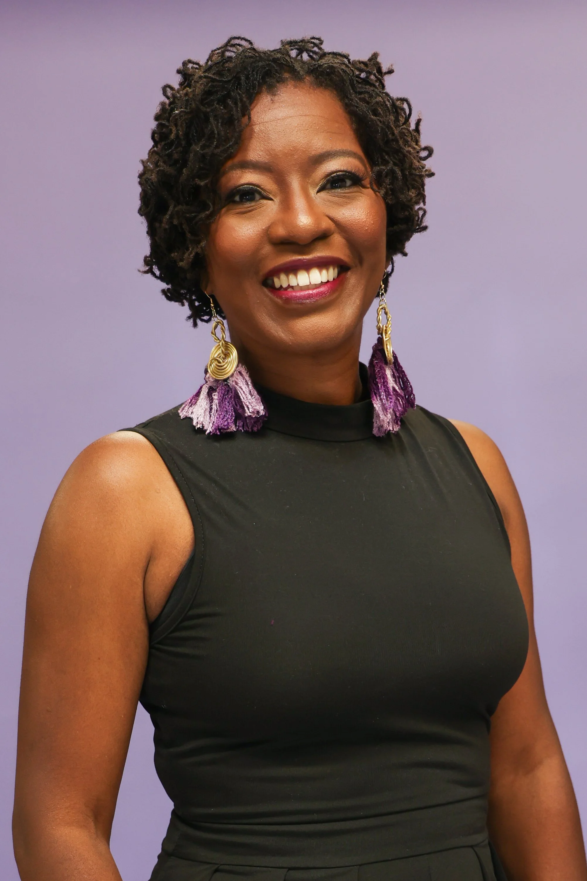 Portrait of Sherenia Branche, Broker Owner of Branche & Associates in Henderson, NC, smiling against a light purple background.