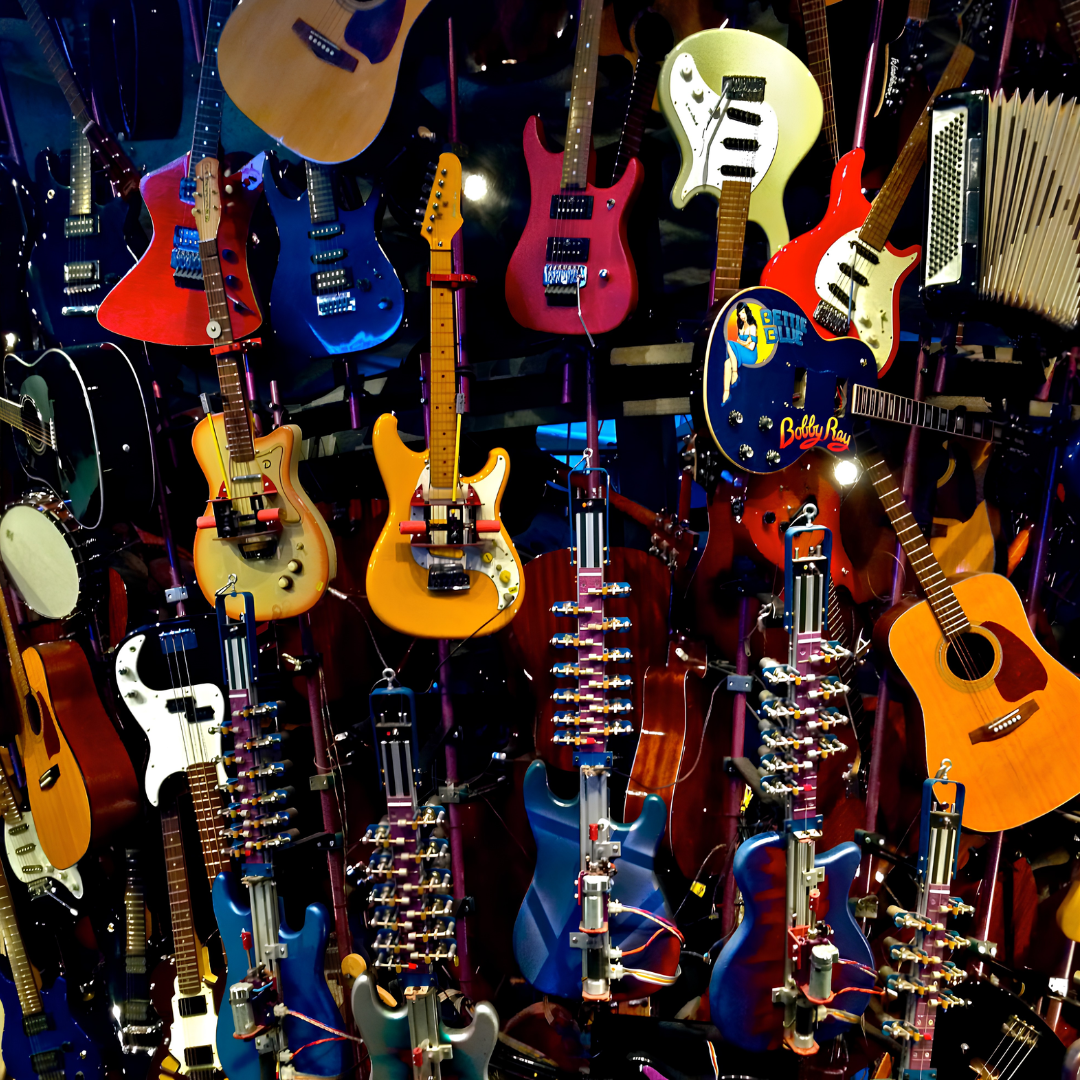 Display of various electric and acoustic guitars hanging on a wall