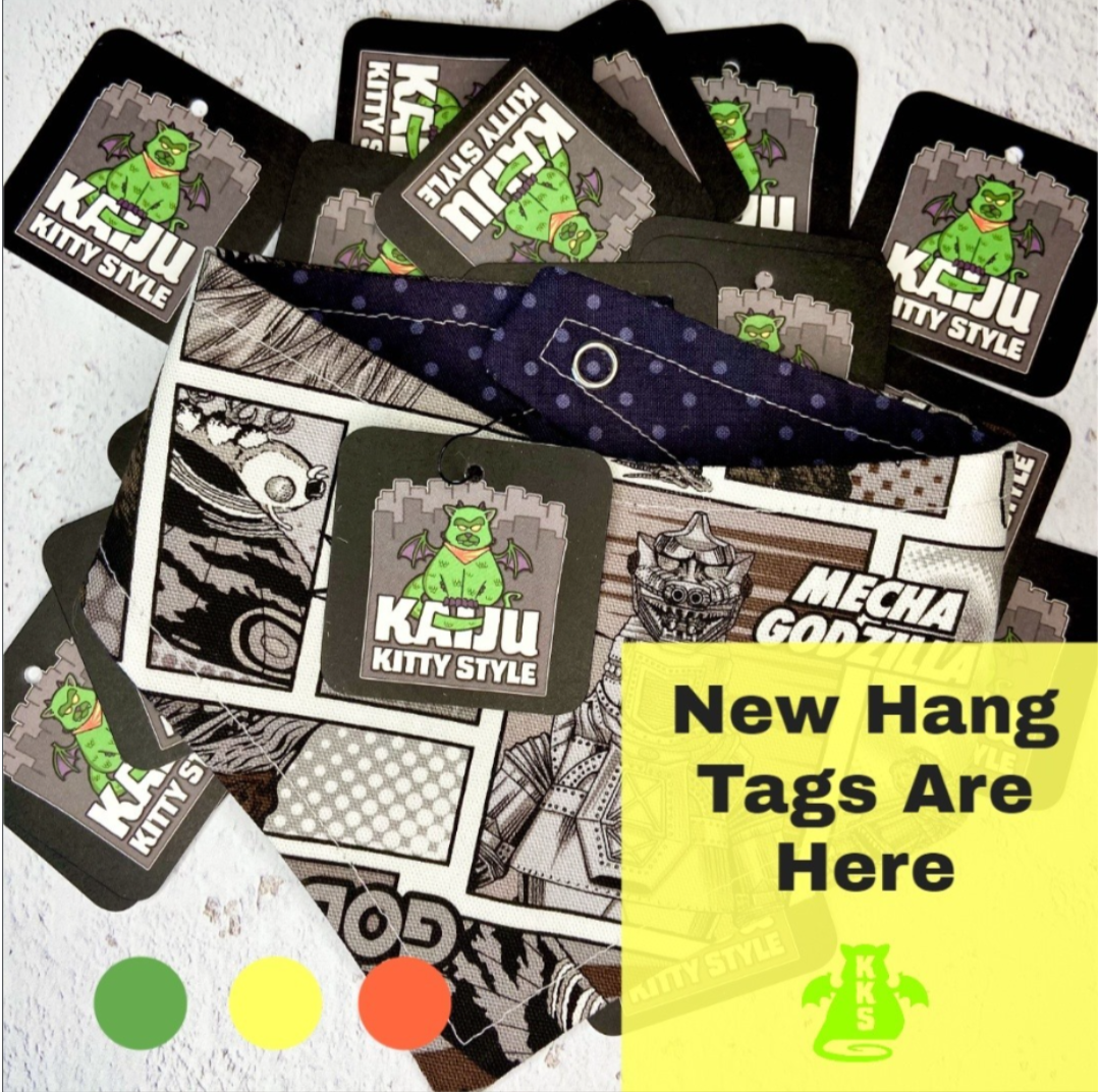 A collection of new Kaju Kitty Style tags, with some tags featuring a green, bat-winged cartoon cat character on a black background. A note on the image says, 'New Hang Tags Are Here' in bold black text on a yellow background.