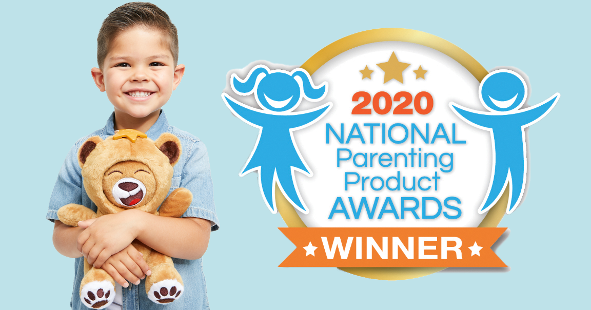 Young boy smiling and holding a plush teddy bear in front of a logo for the 2020 National Parenting Product Awards, indicating he is a winner.