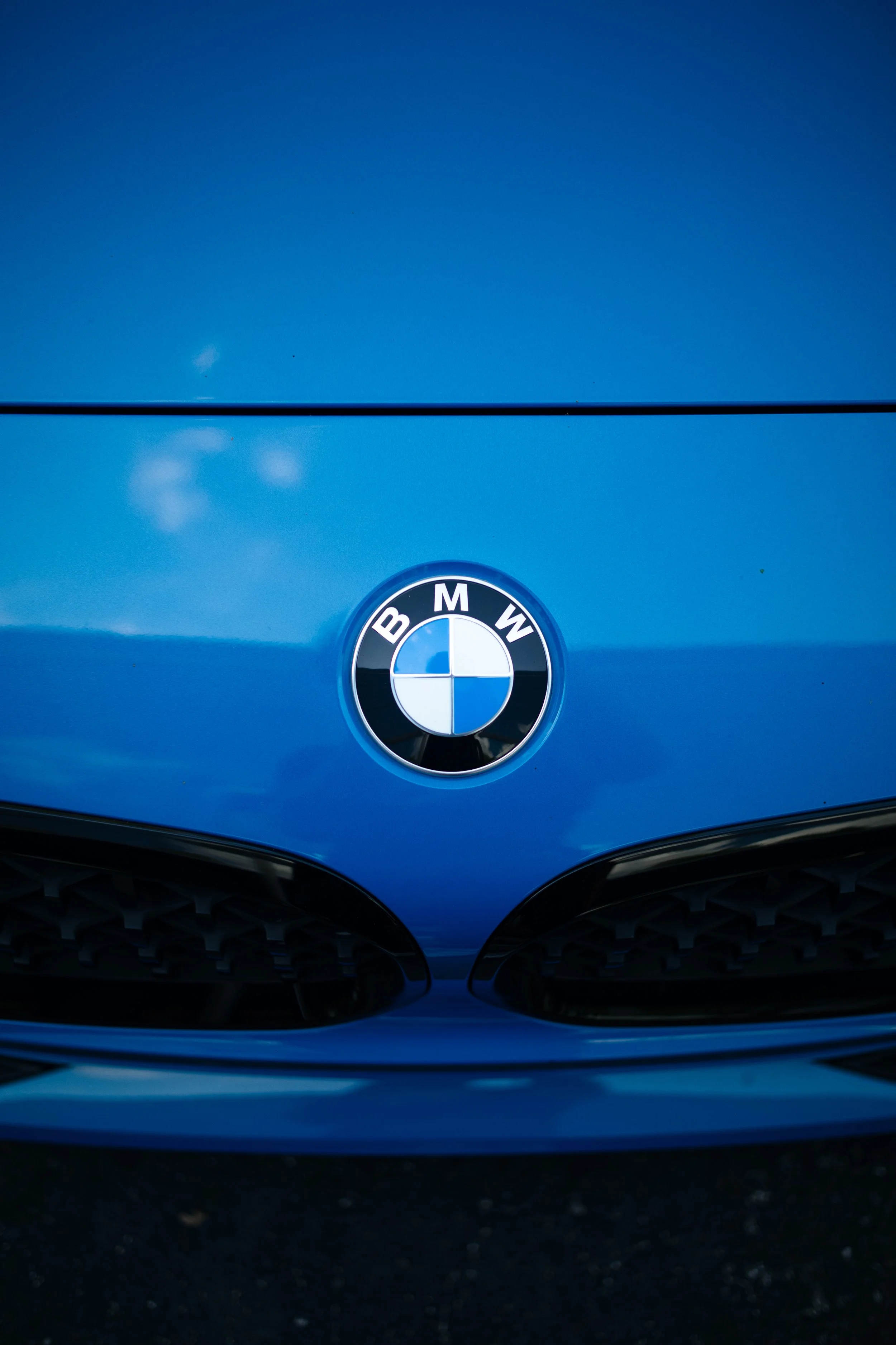 Front view of a blue BMW car with the BMW emblem visible on the hood.