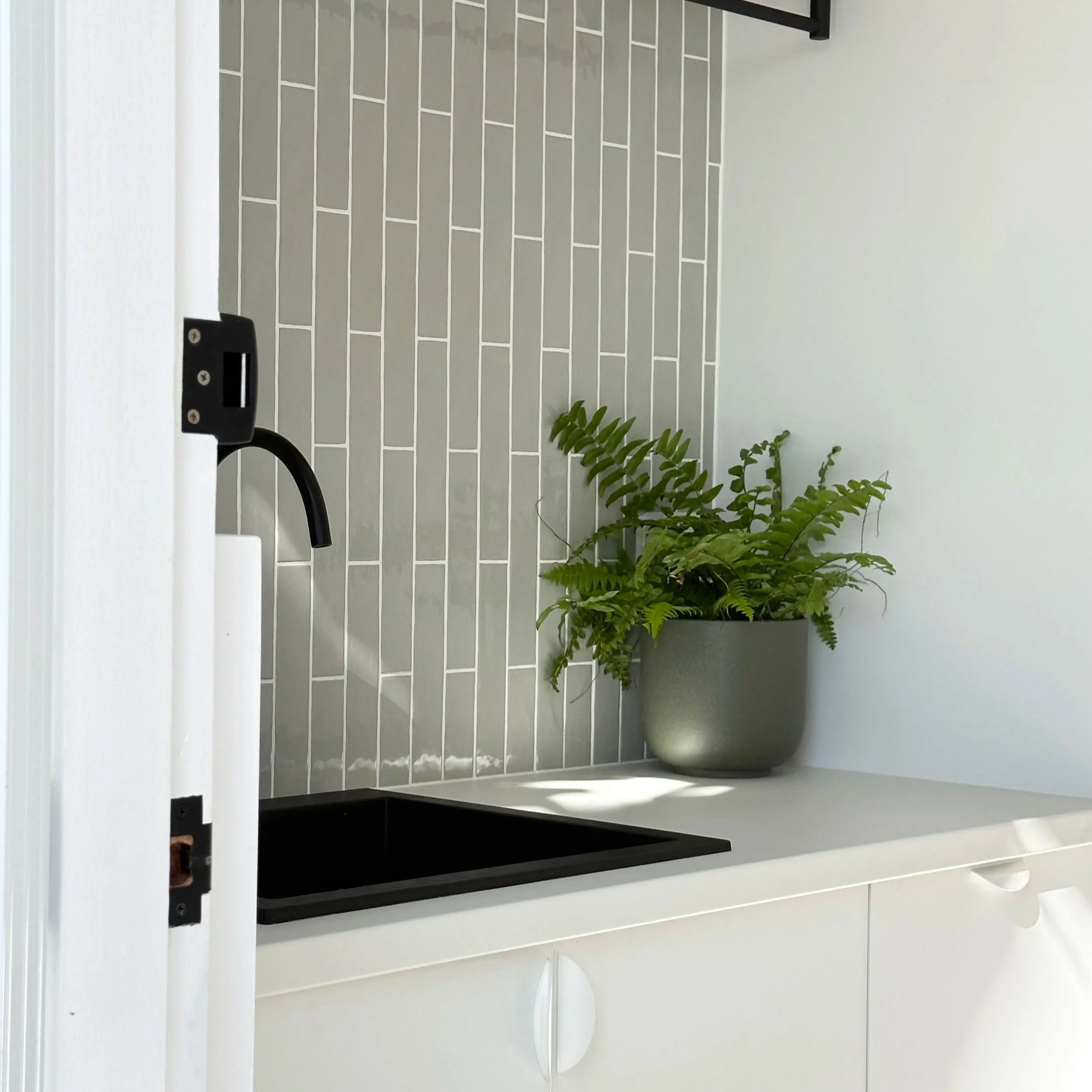 Custom laundry cabinetry with stone benchtop in Glenelg South