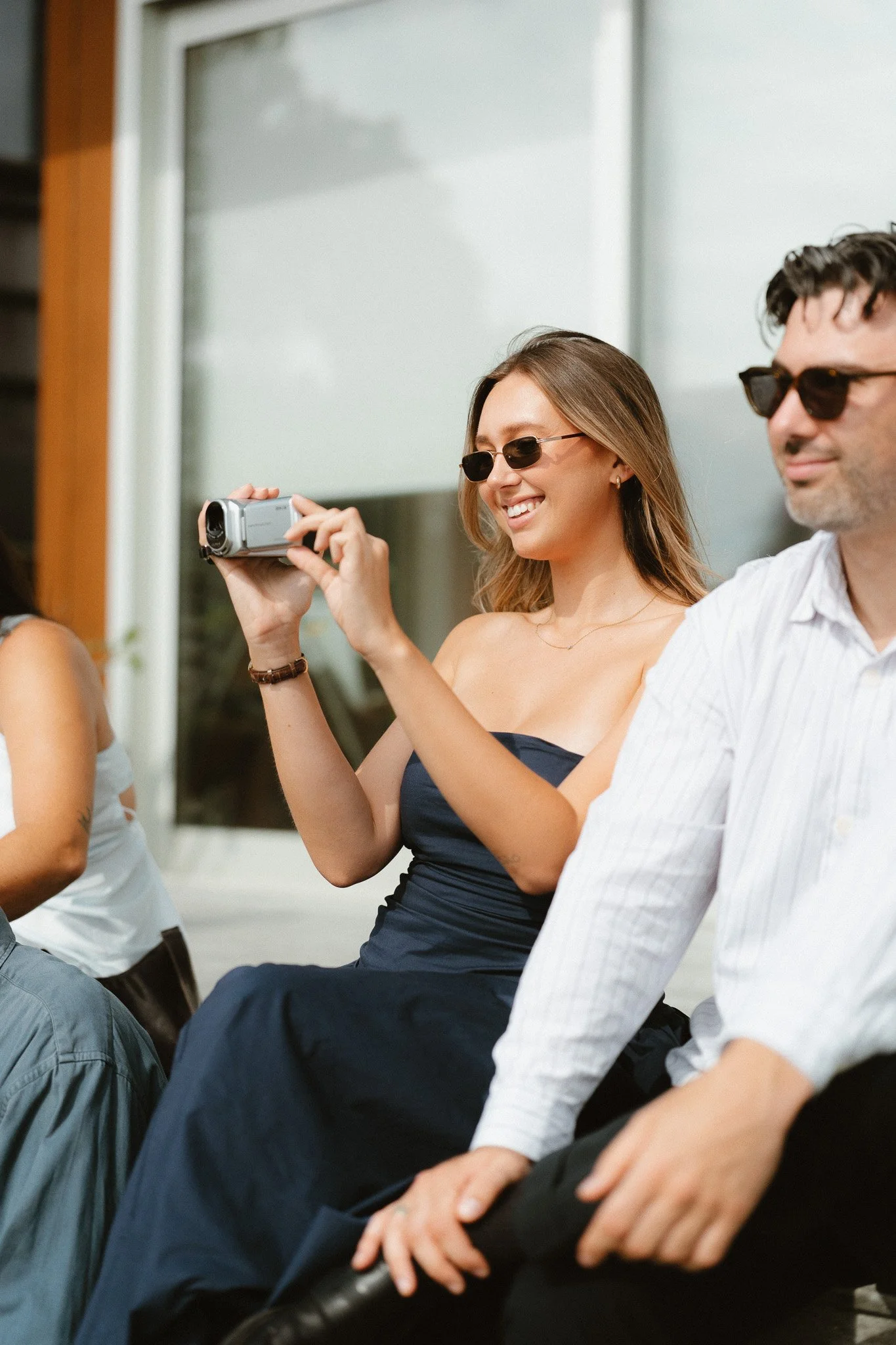Guest filming candid wedding moments with a handheld camcorder