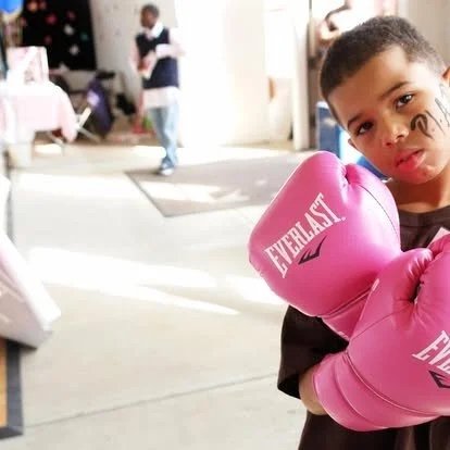 Kim's Surviving son with pink boxing gloves.