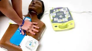 A person undergoing a medical procedure, with medical equipment and a healthcare professional's hand on their chest.