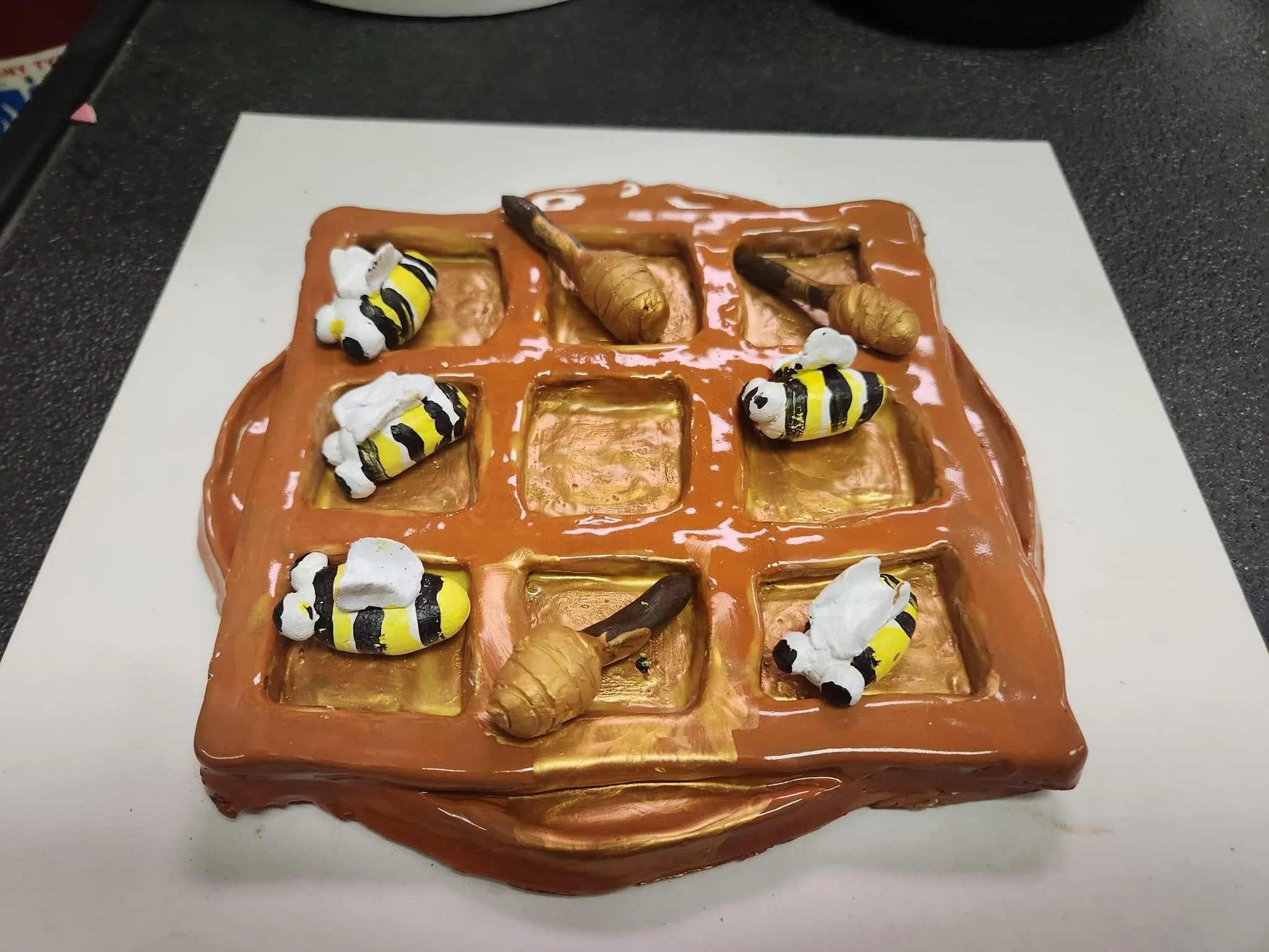 A chocolate cake decorated with bees and honeycombs made of candy or fondant.