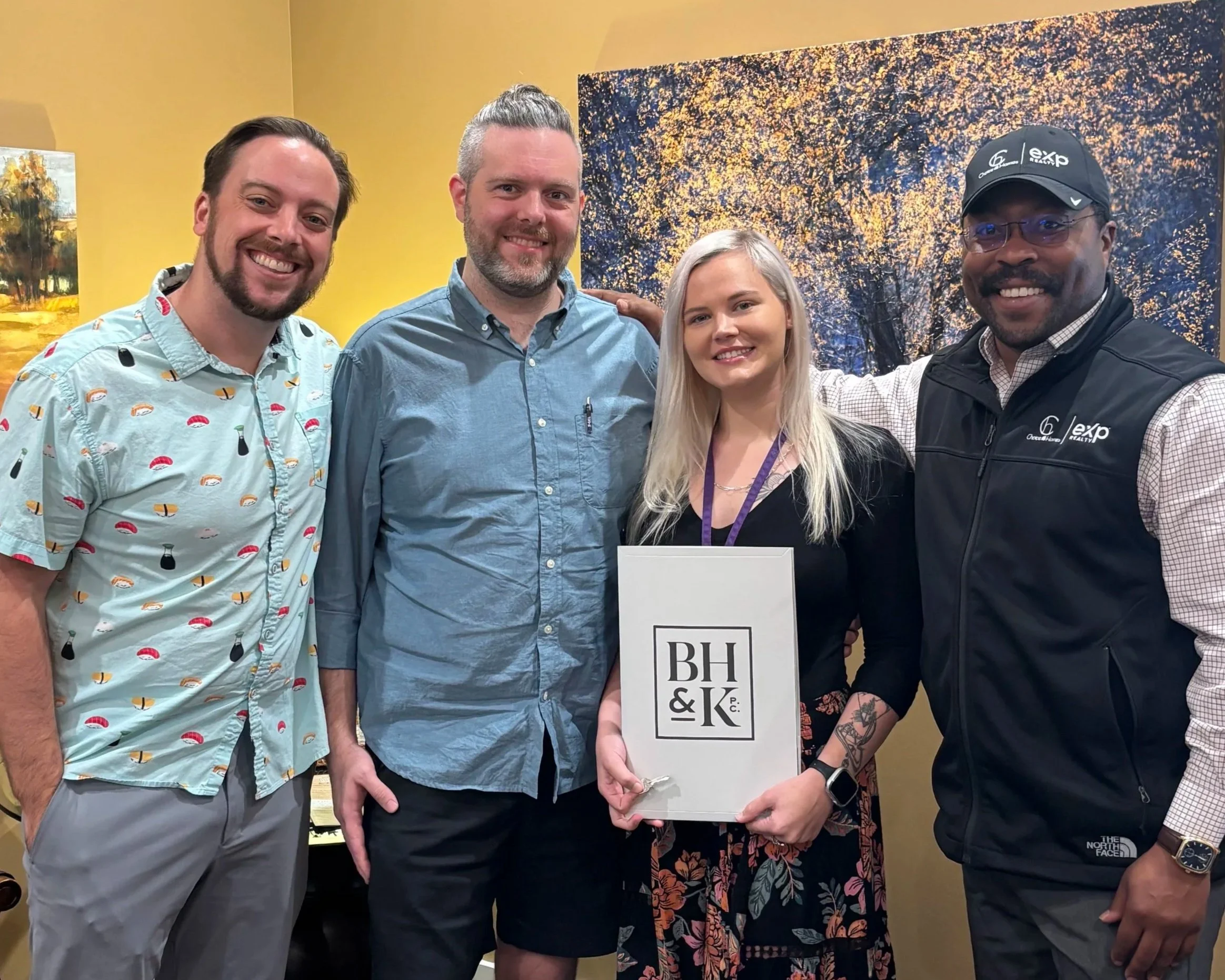 Corey and team, smiling holding documents for closings.