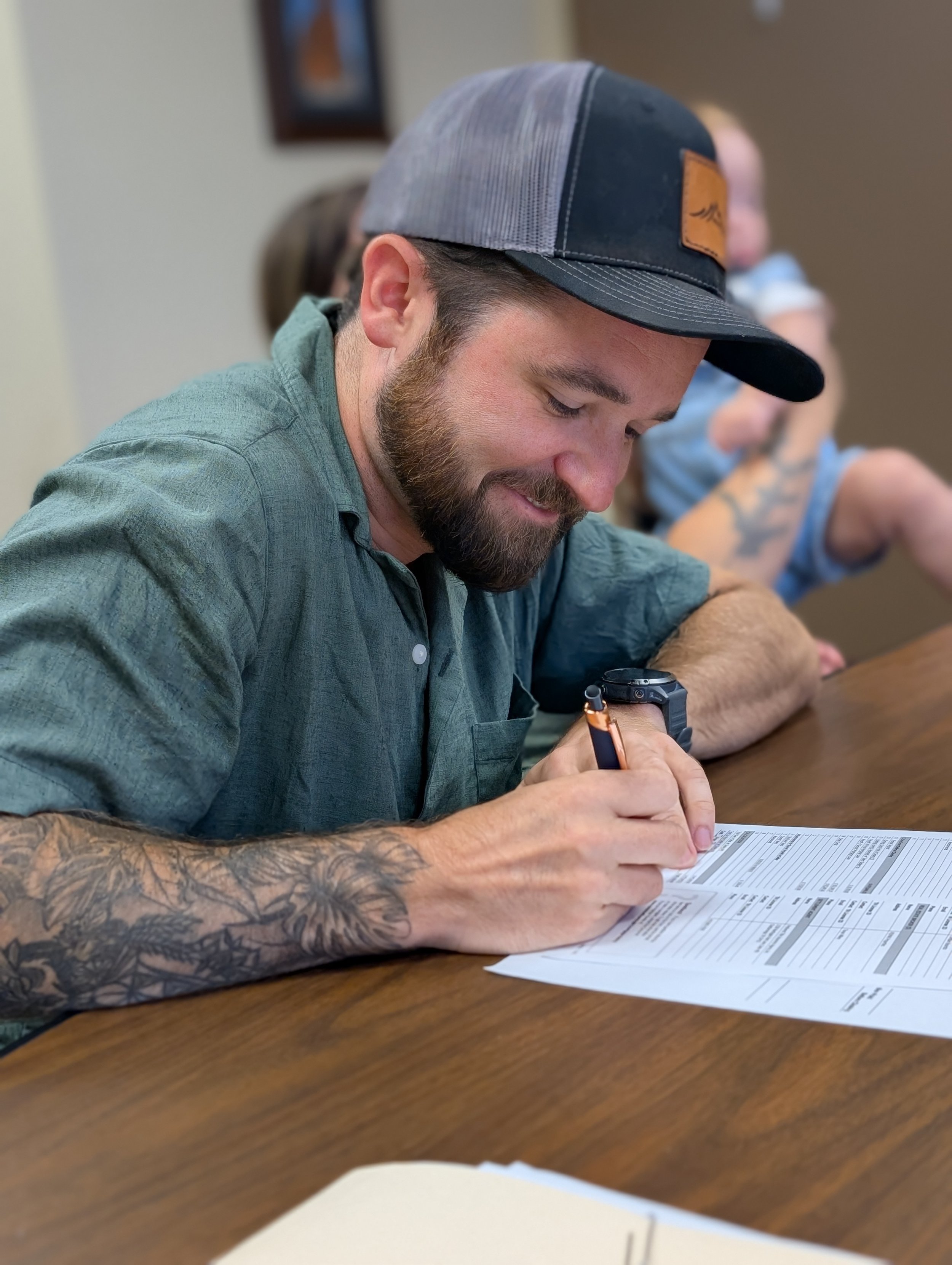 A man signing a document associated with purchasing a home
